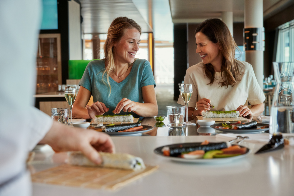 Zwei Frauen sitzen am Tisch und genießen ein Sushi-Workshop.