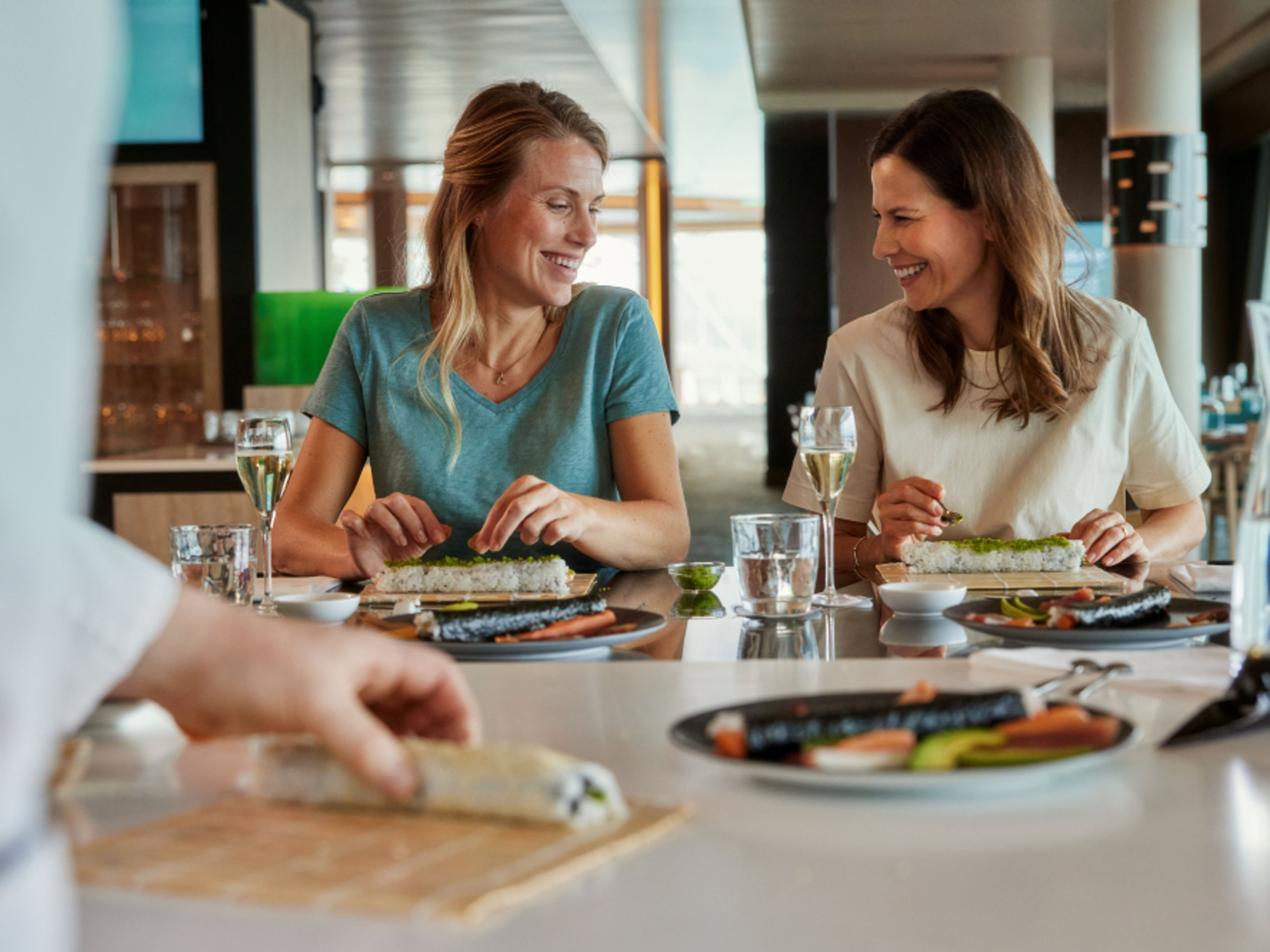 Zwei Frauen sitzen am Tisch und genießen ein Sushi-Workshop. Zwei Frauen sitzen am Tisch und genießen ein Sushi-Workshop.