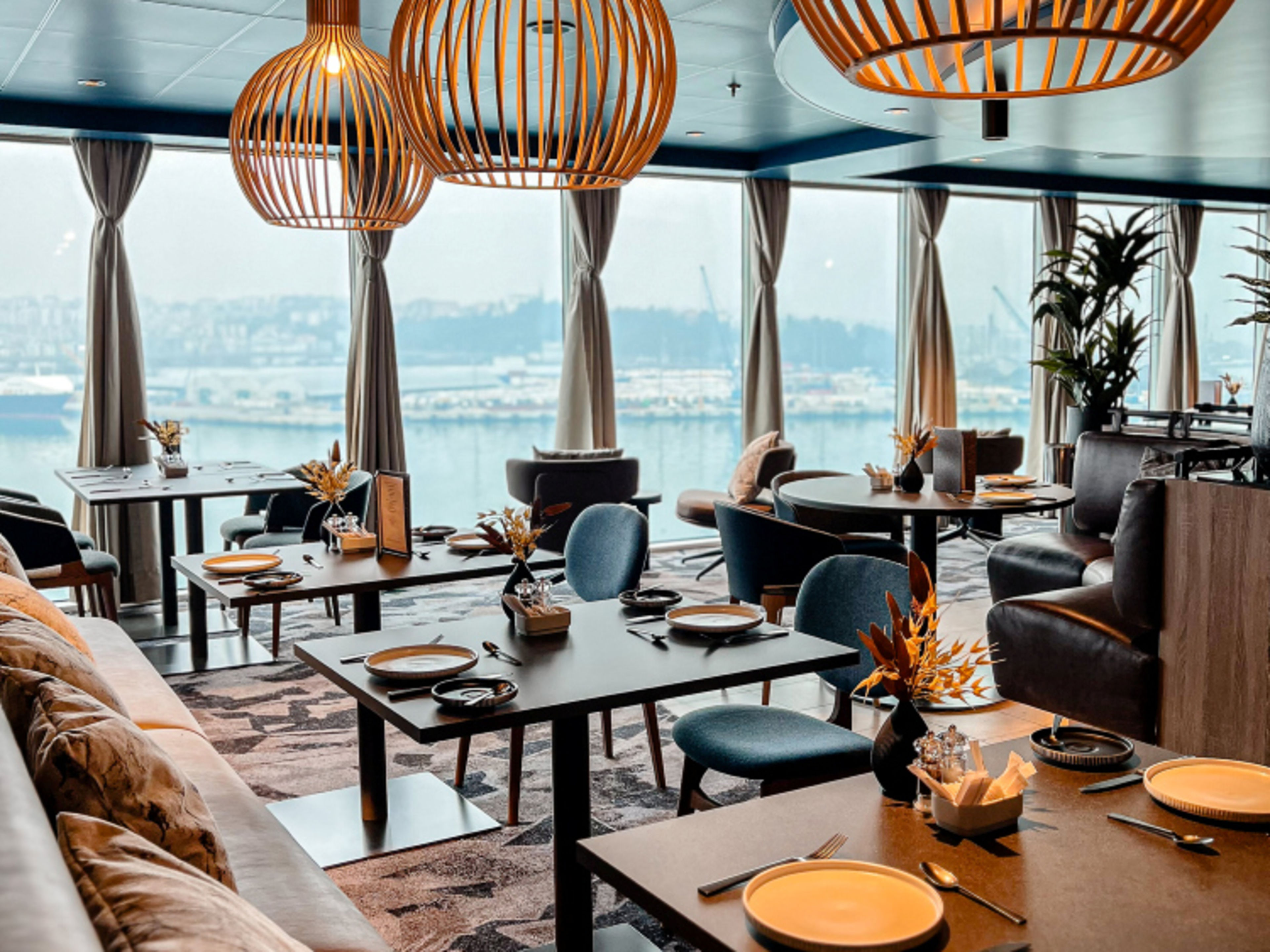 Restaurant Høfde with modern lamps, set tables, harbour view. Restaurant Høfde with modern lamps, set tables, harbour view.