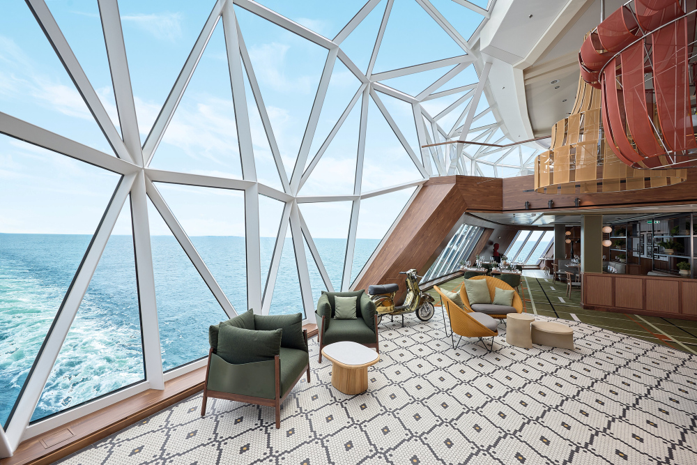 The elegant La Spezia lounge area on Mein Schiff® 7, offering sea views through a geodesic glass front.