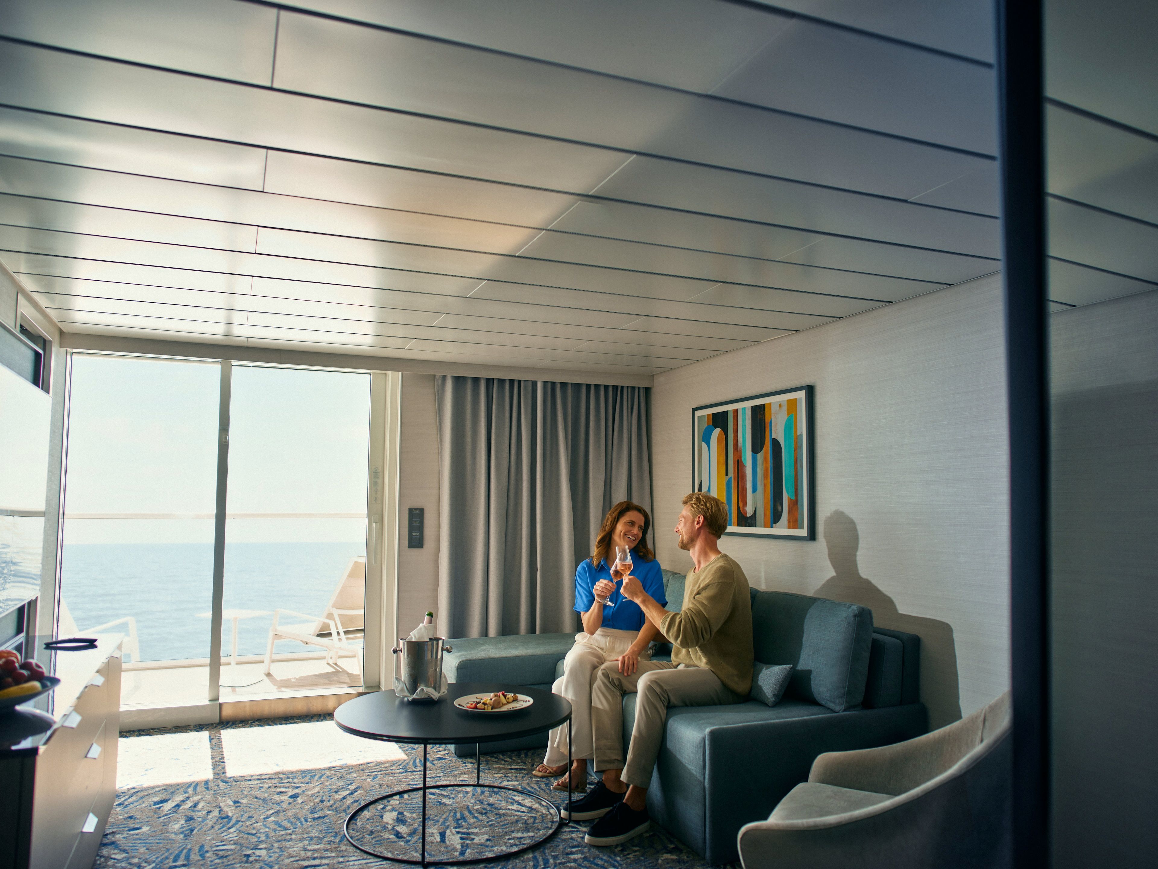 A couple toasts with champagne in a bright cabin with a view of the sea. A couple toasts with champagne in a bright cabin with a view of the sea.