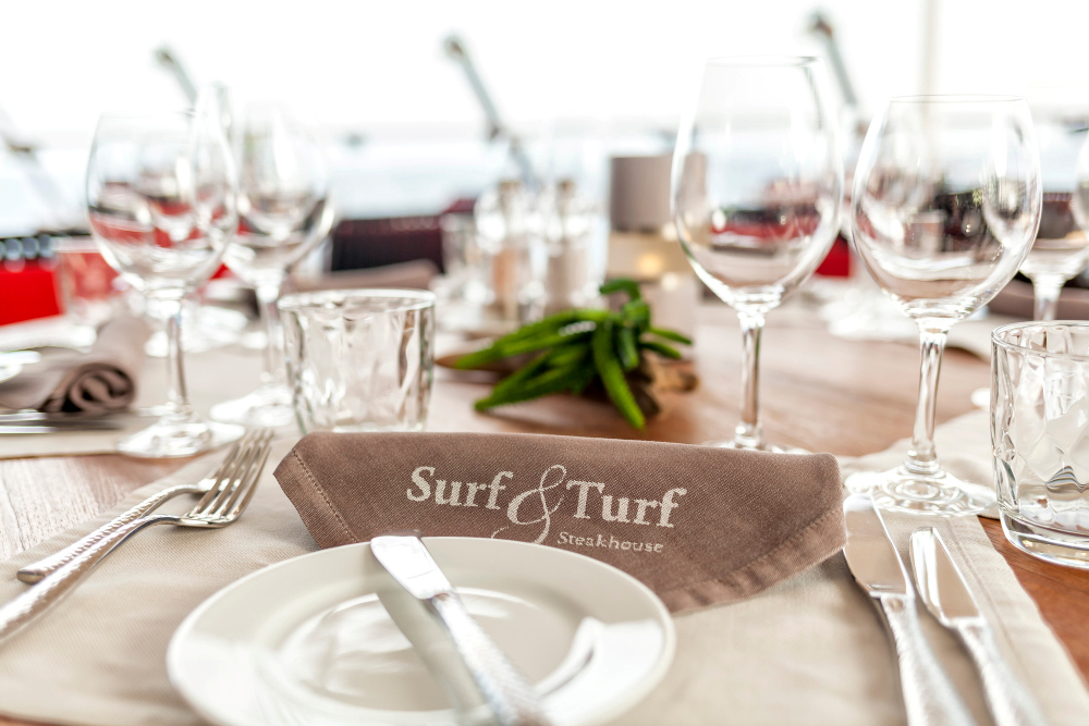 A table set at the Surf & Turf Steakhouse with glasses and cutlery.