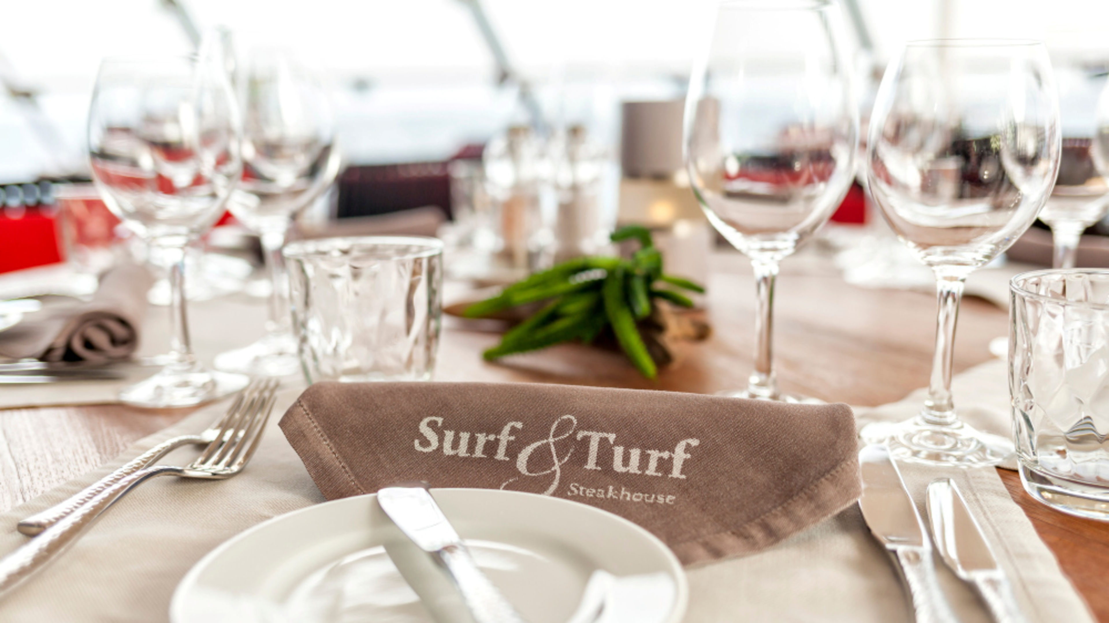 A table set at the Surf & Turf Steakhouse with glasses and cutlery. A table set at the Surf & Turf Steakhouse with glasses and cutlery.