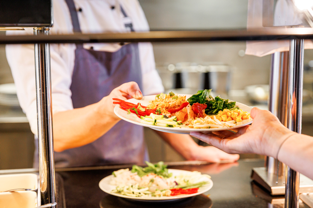 The chef serves a colourful dish with vegetables.