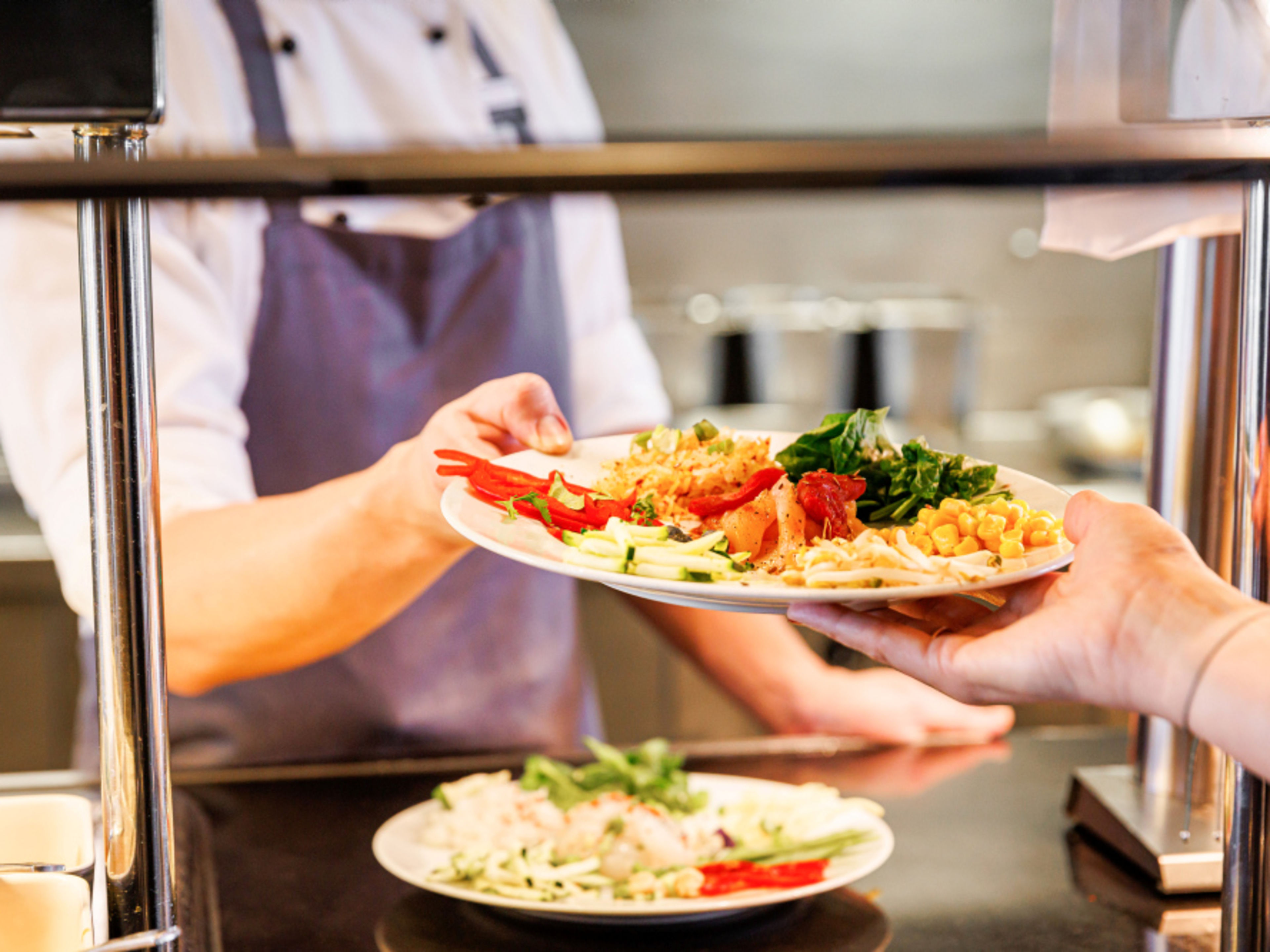 The chef serves a colourful dish with vegetables. The chef serves a colourful dish with vegetables.