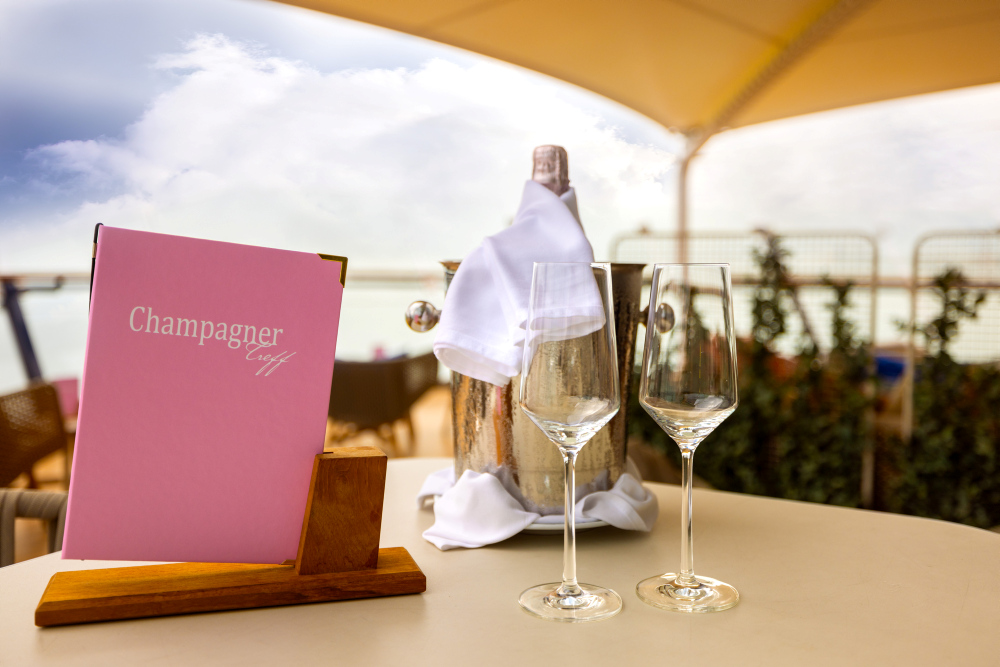 Champagne cooler with a bottle, two glasses and the Champagne Treff drinks menu 