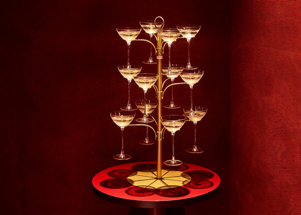 Champagne pyramid in front of red armchairs and sofa in an elegant room.