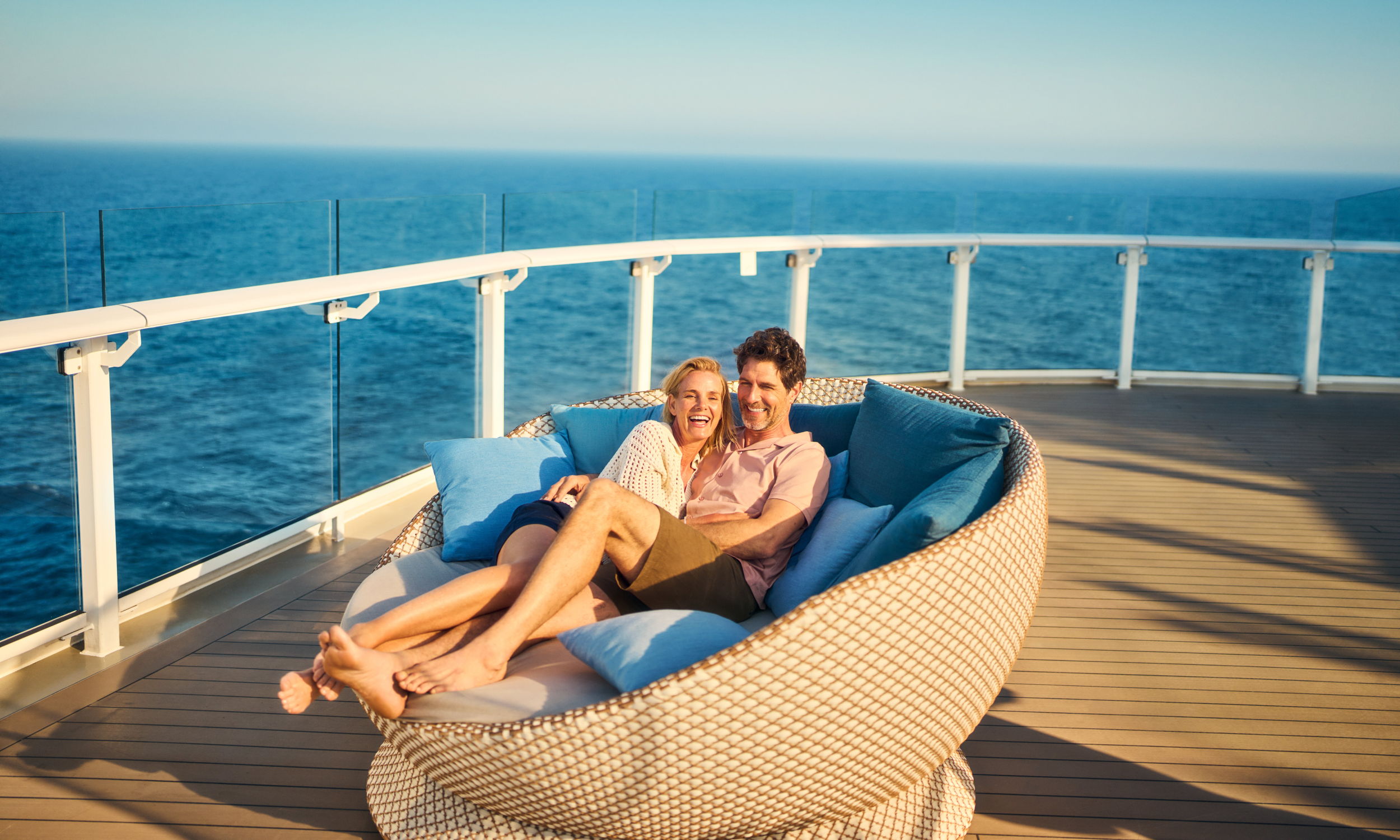 Couple cuddling in the daybed on their honeymoon cruise