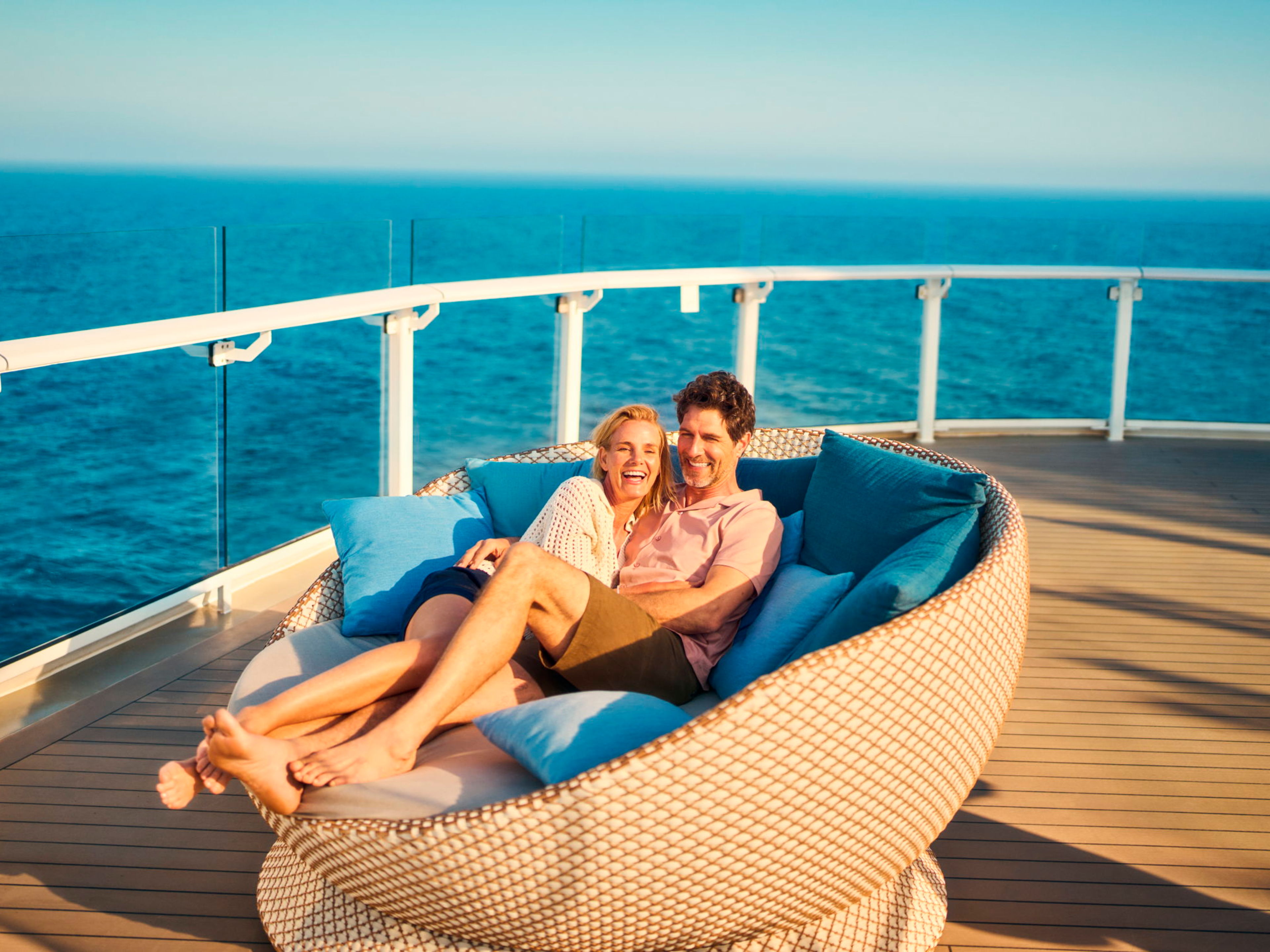 Couple cuddling in the daybed on their honeymoon cruise Couple cuddling in the daybed on their honeymoon cruise