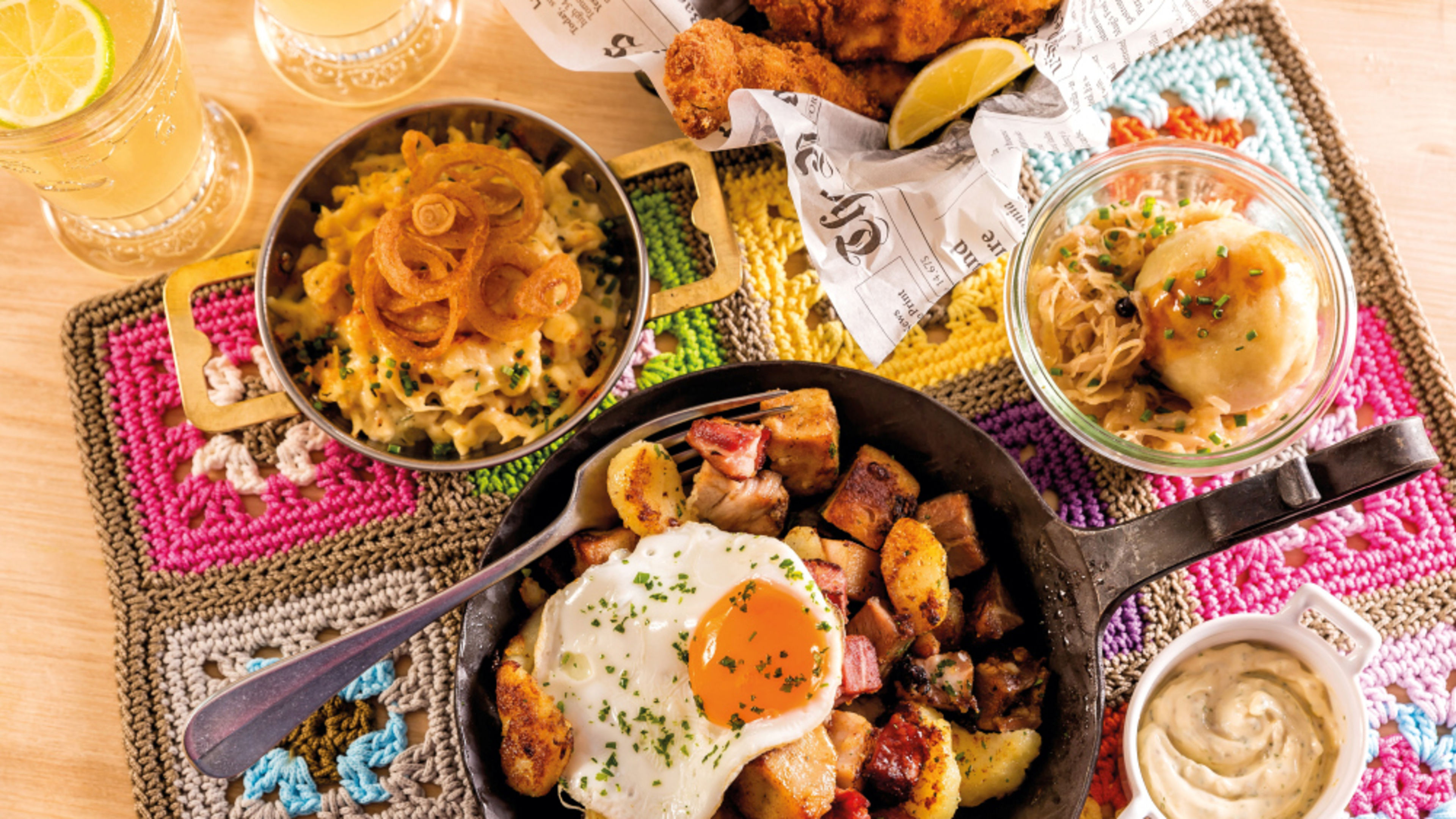 A hearty brunch with fried eggs, fried potatoes, cheese spaetzle, sauerkraut and drinks, served on a colourful placemat. A hearty brunch with fried eggs, fried potatoes, cheese spaetzle, sauerkraut and drinks, served on a colourful placemat.