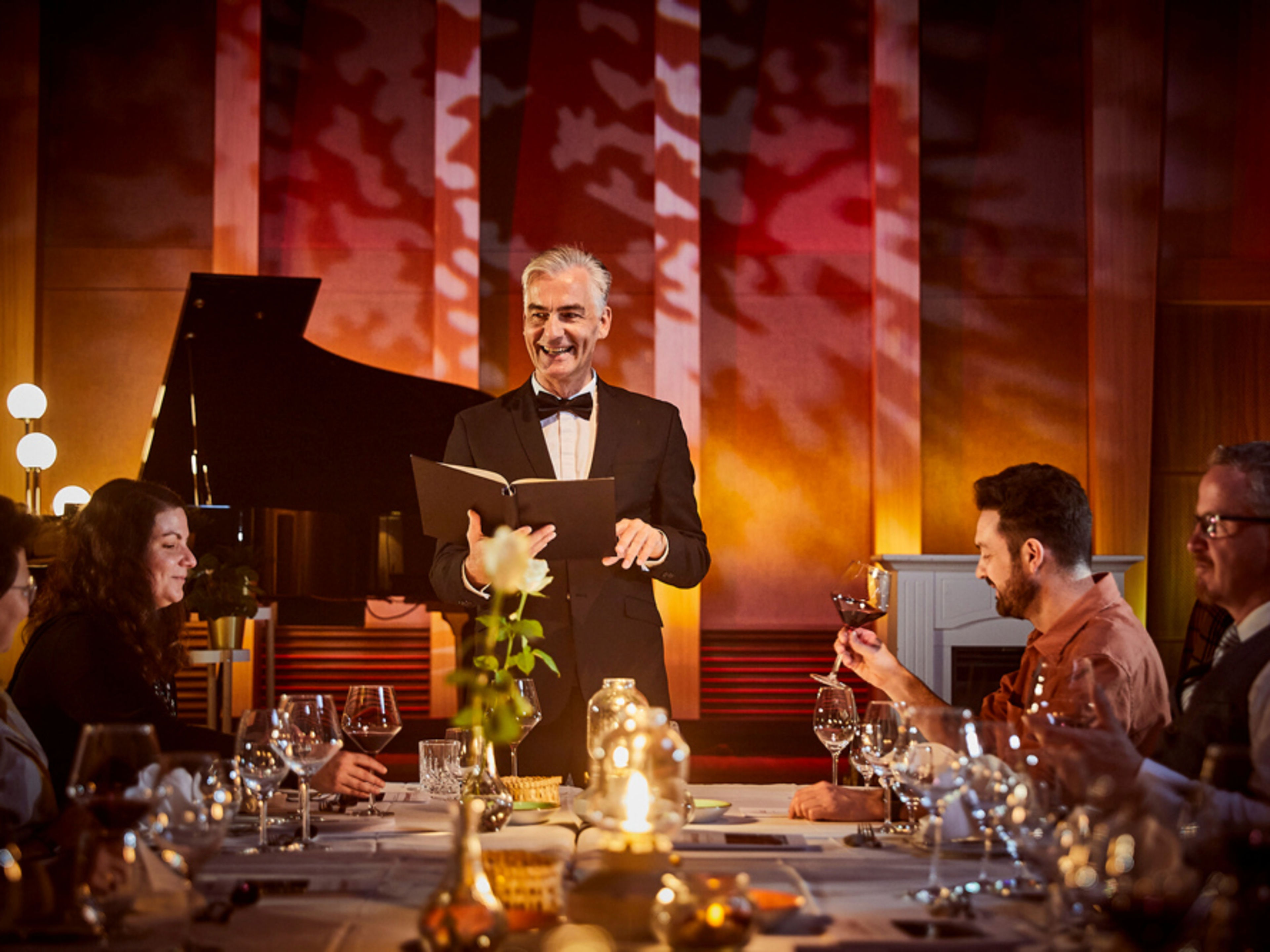 Ein Schauspieler steht vorne am Tisch und liest. Ein Schauspieler steht vorne am Tisch und liest.