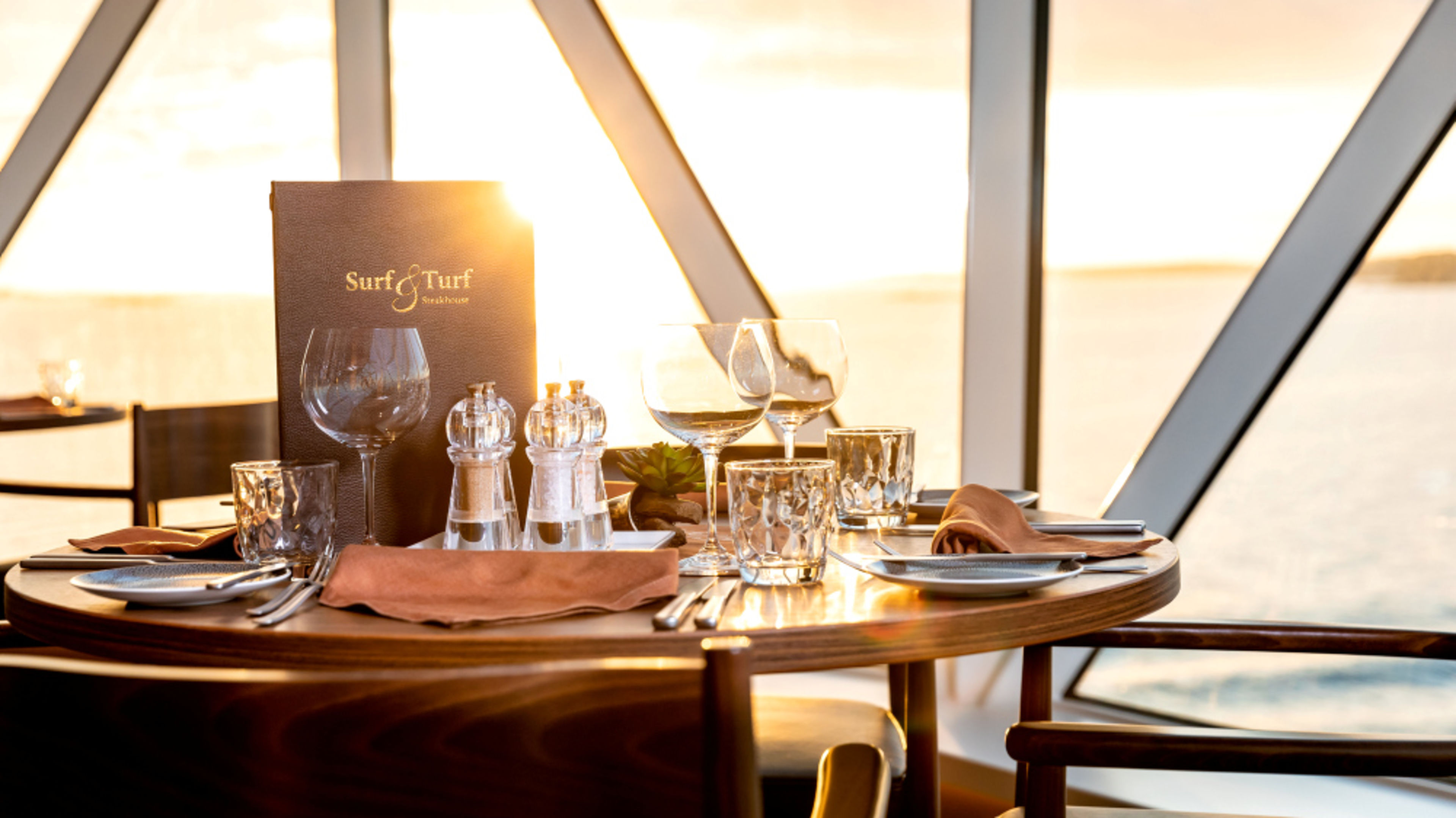 A table set at the Surf & Turf Steakhouse at sunset. A table set at the Surf & Turf Steakhouse at sunset.