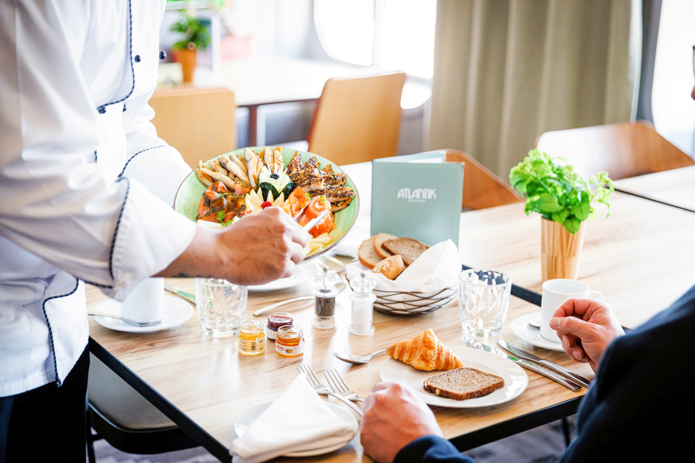 A waiter serves breakfast plates in the Atlantik Restaurant.