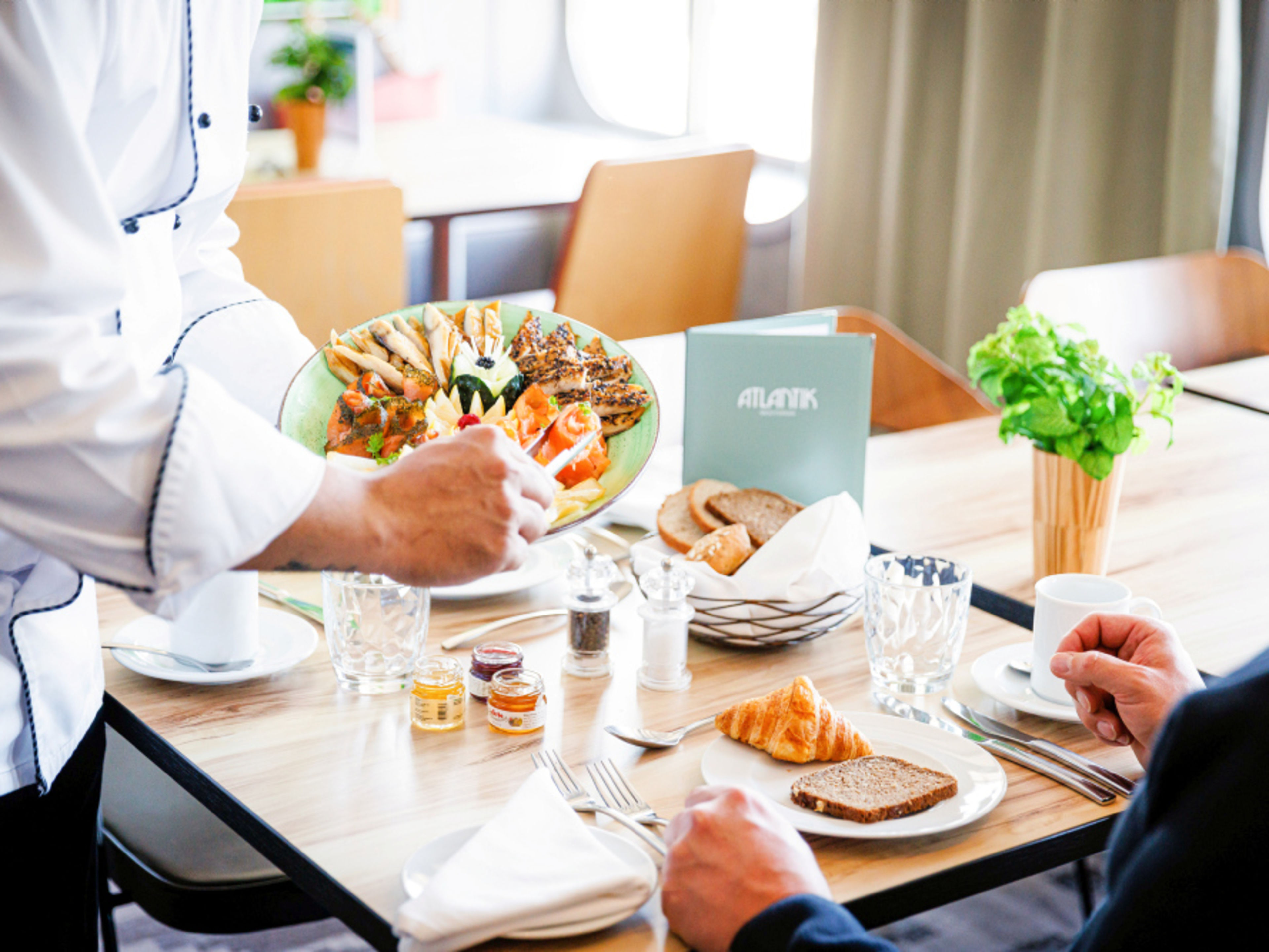 A waiter serves breakfast plates in the Atlantik Restaurant. A waiter serves breakfast plates in the Atlantik Restaurant.