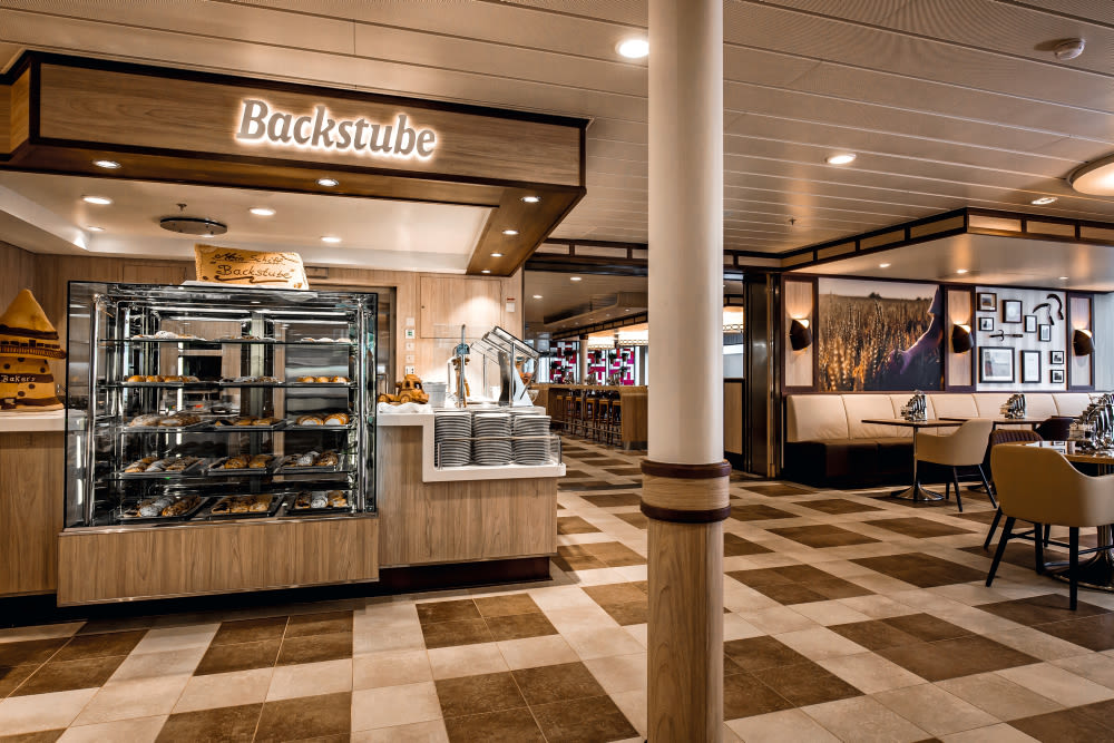 A bakery on a cruise ship with a bakery counter and a cozy seating area.