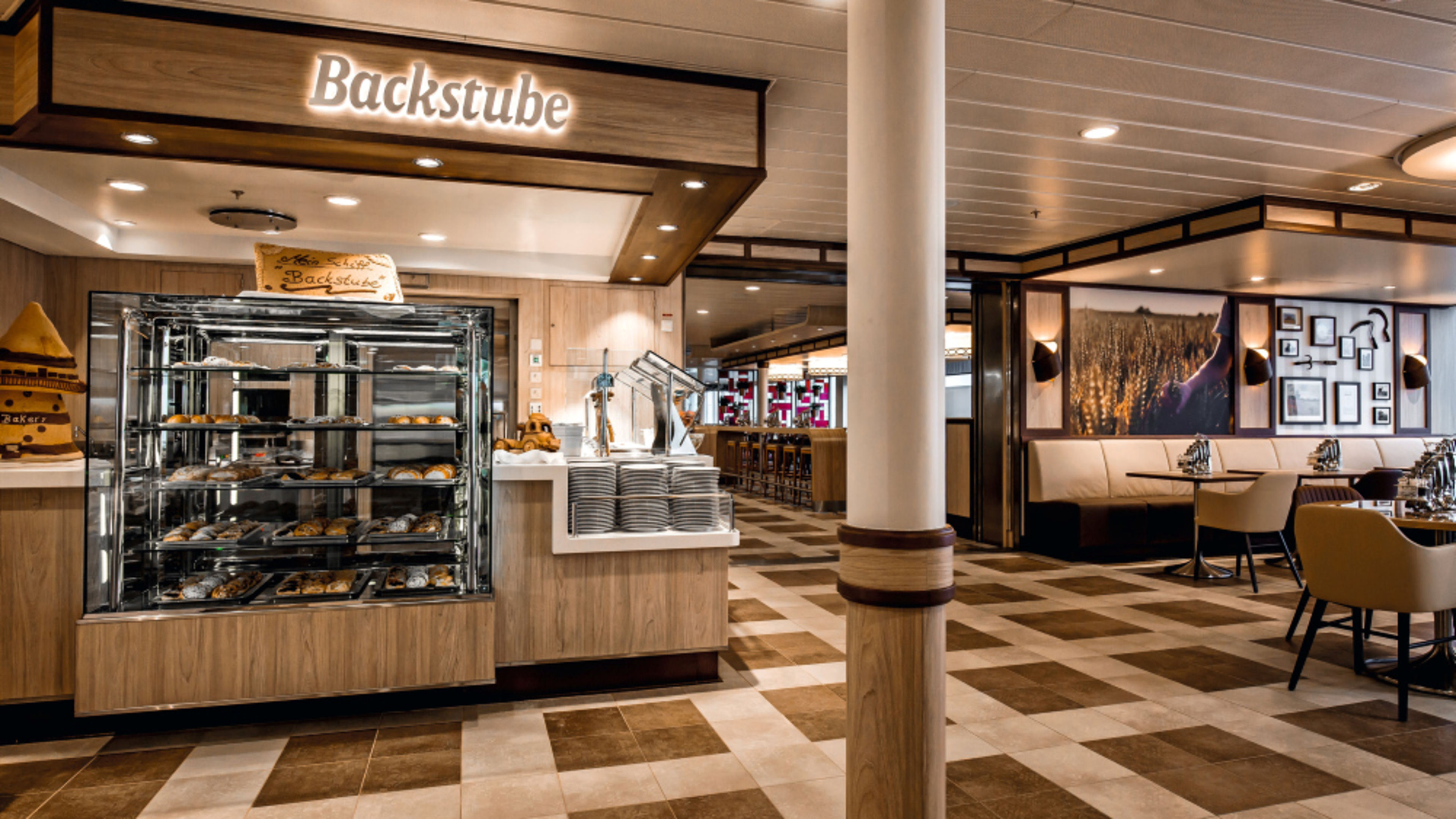 A bakery on a cruise ship with a bakery counter and a cozy seating area. A bakery on a cruise ship with a bakery counter and a cozy seating area.