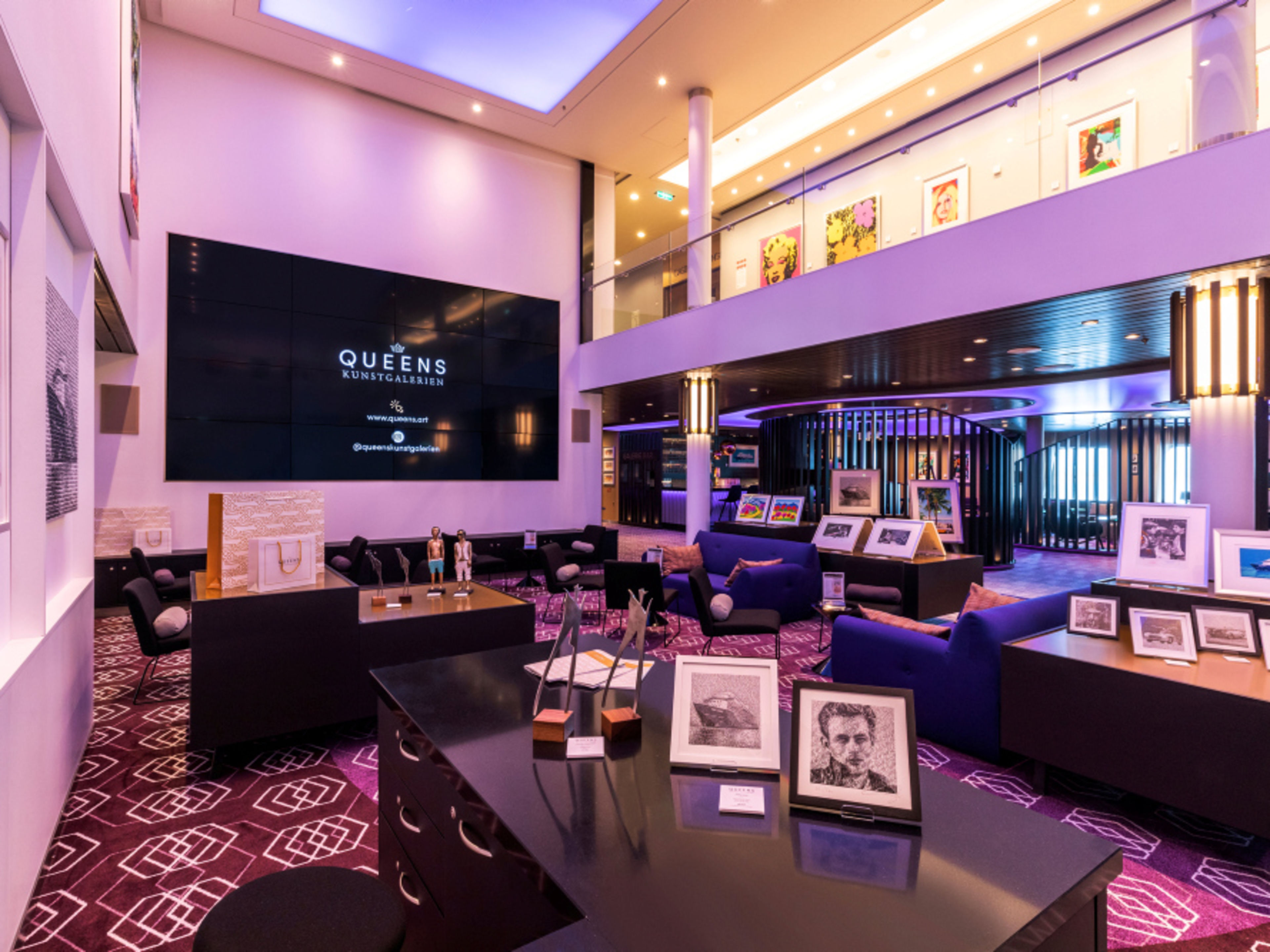 Queens Art Gallery Lounge, featuring artworks, purple lighting and seating areas in a modern interior Queens Art Gallery Lounge, featuring artworks, purple lighting and seating areas in a modern interior