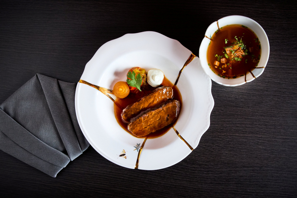 Japanese meat dish with sauce and colourful decoration, served on a white porcelain plate.