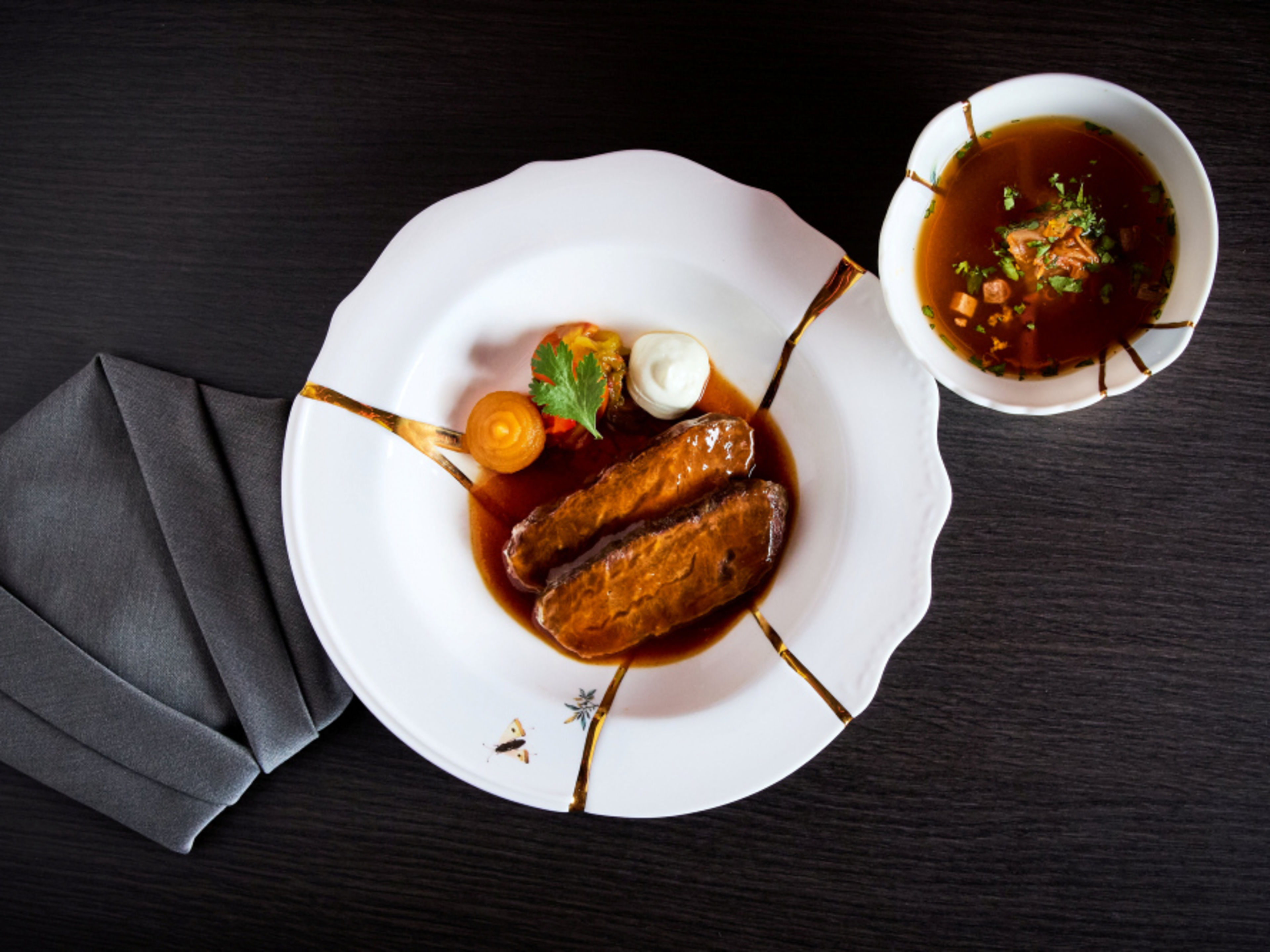 Japanese meat dish with sauce and colourful decoration, served on a white porcelain plate. Japanese meat dish with sauce and colourful decoration, served on a white porcelain plate.
