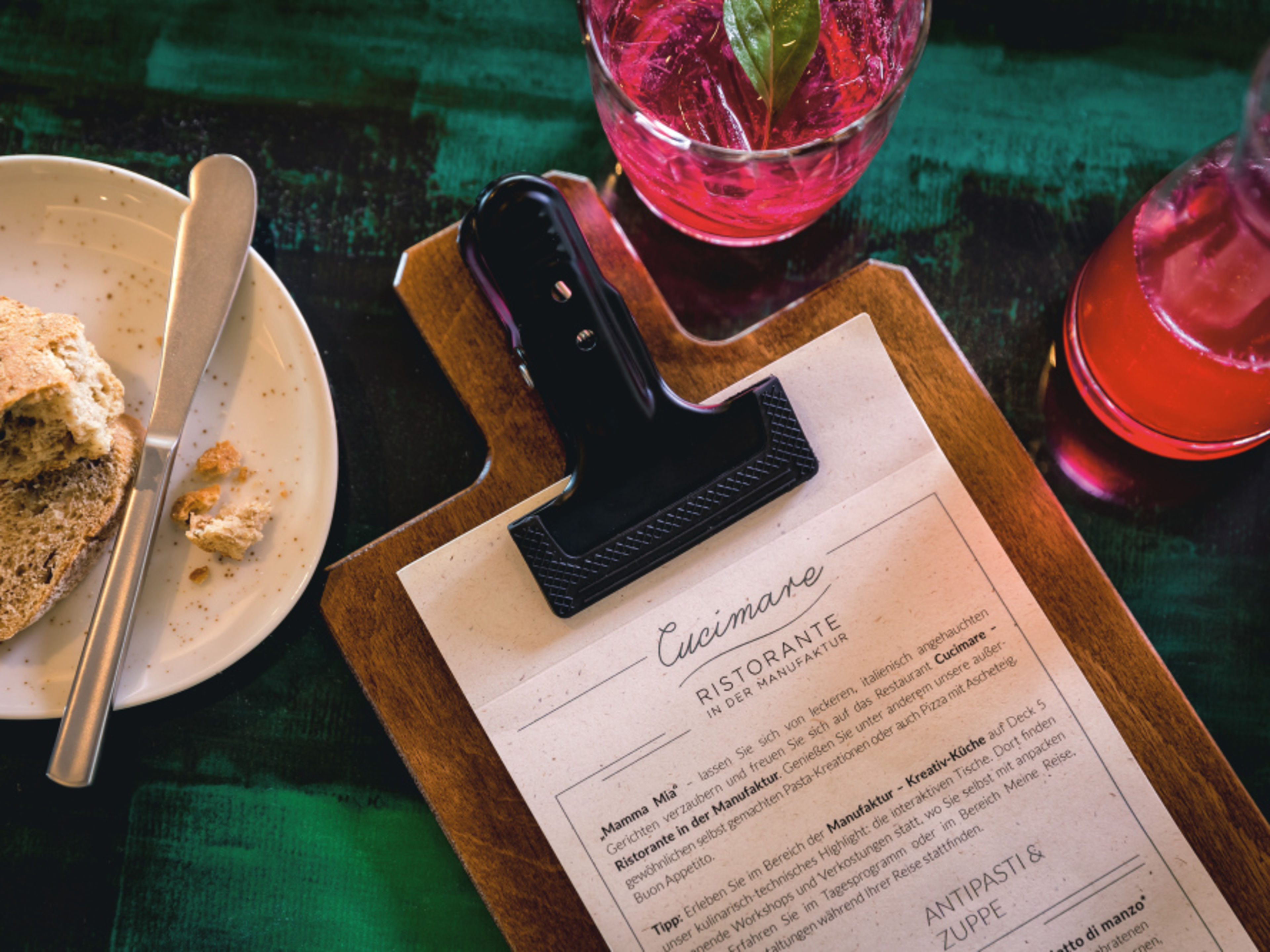 Cucimare menu on a wooden board, bread on a plate, red drink. Cucimare menu on a wooden board, bread on a plate, red drink.