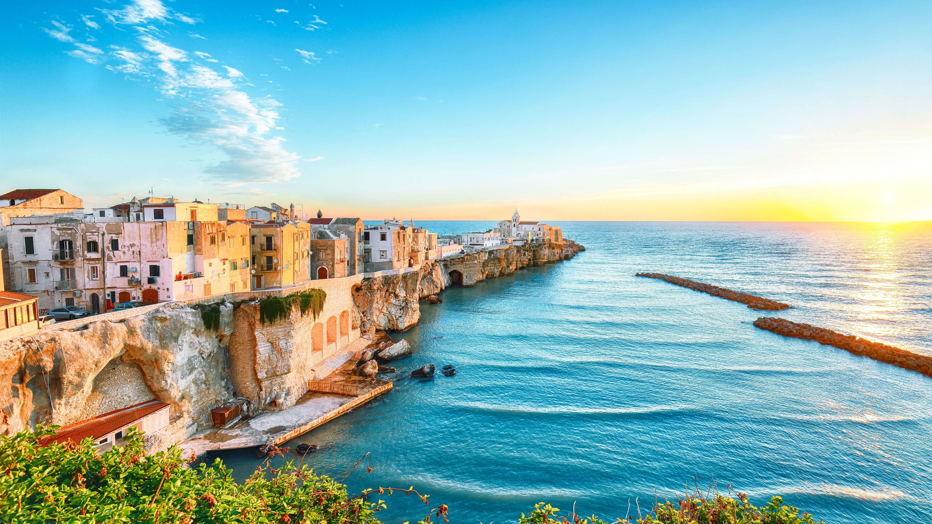 Küstenstadt Vieste bei Sonnenuntergang, bunte Häuser, blaues Meer. Küstenstadt Vieste bei Sonnenuntergang, bunte Häuser, blaues Meer.