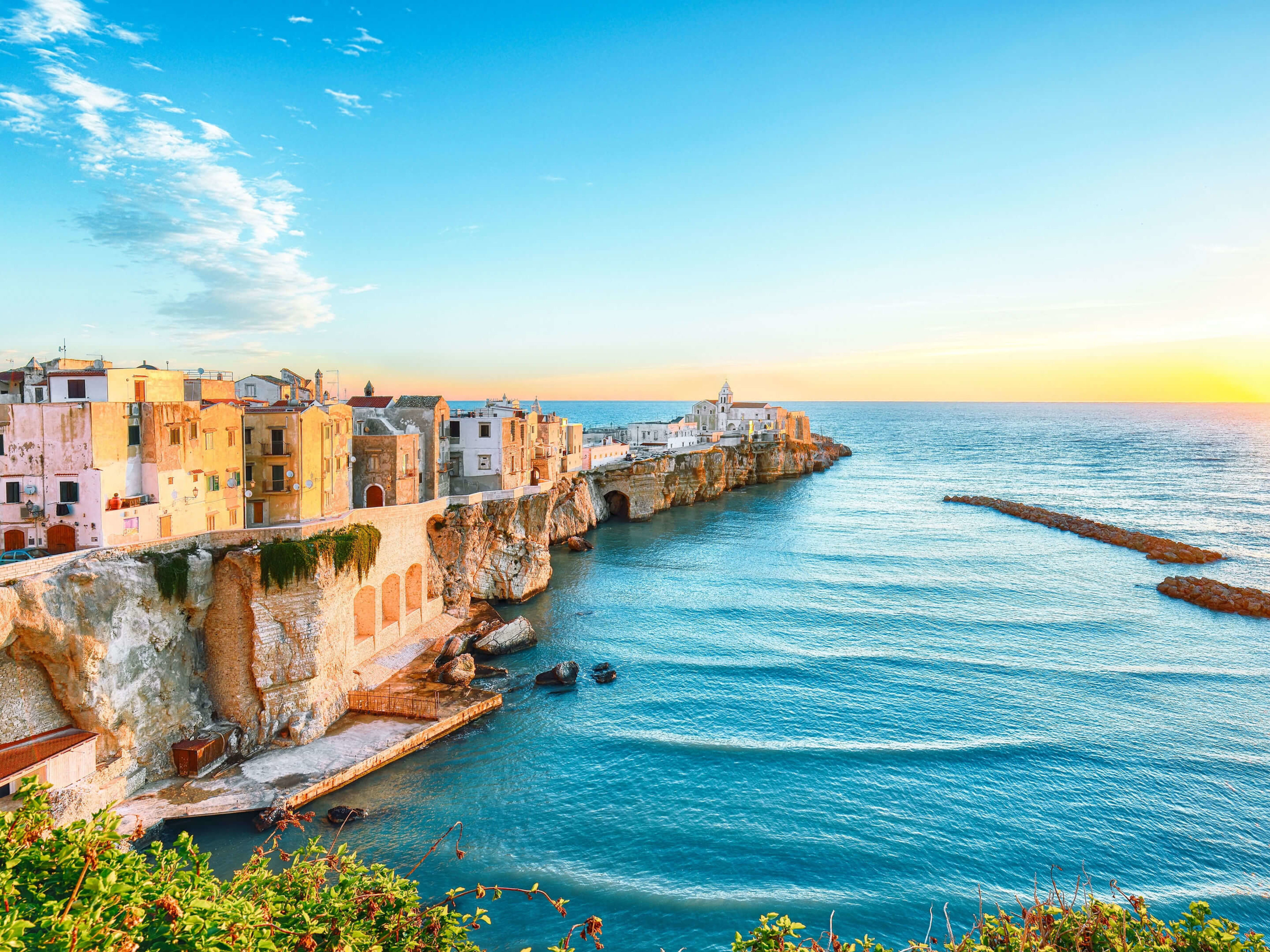Küstenstadt Vieste bei Sonnenuntergang, bunte Häuser, blaues Meer. Küstenstadt Vieste bei Sonnenuntergang, bunte Häuser, blaues Meer.