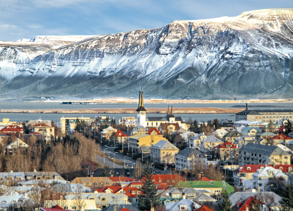 Reykjavik mit schneebedeckten Bergen im Hintergrund, bunte Häuser. Reykjavik mit schneebedeckten Bergen im Hintergrund, bunte Häuser.