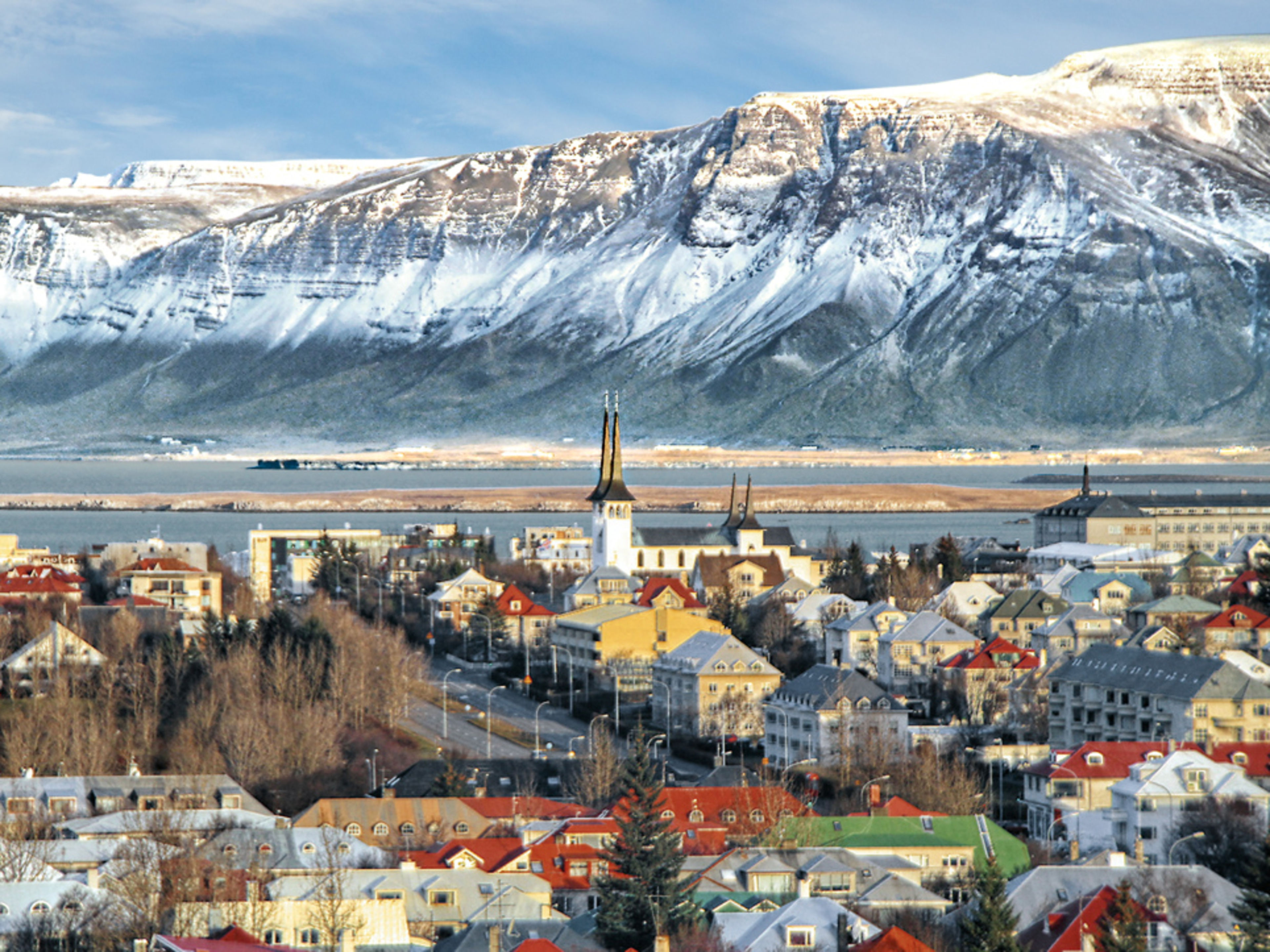 Reykjavik mit schneebedeckten Bergen im Hintergrund, bunte Häuser. Reykjavik mit schneebedeckten Bergen im Hintergrund, bunte Häuser.
