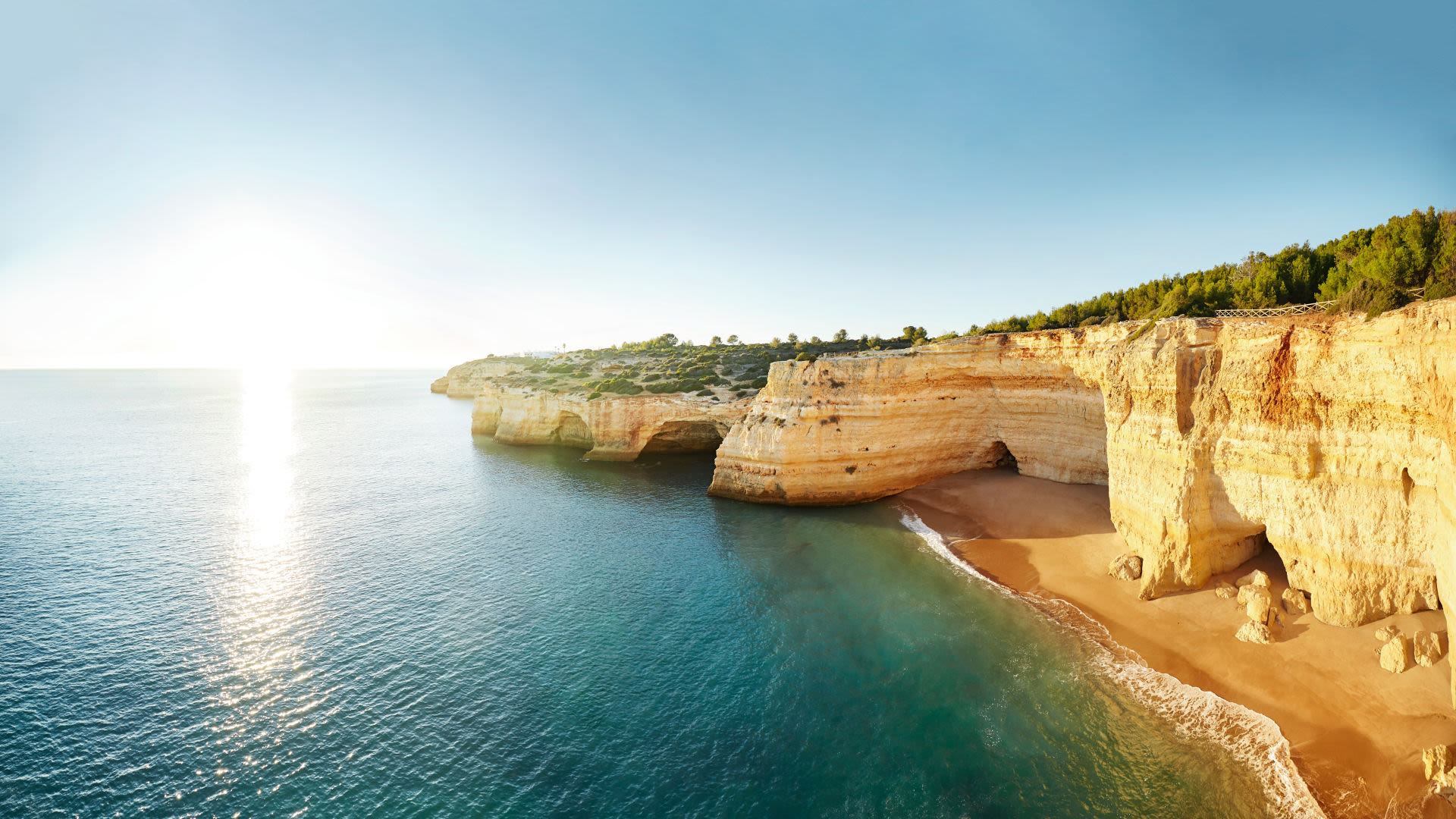 Küste der Algarve mit goldenen Klippen und blauem Meer. Küste der Algarve mit goldenen Klippen und blauem Meer.