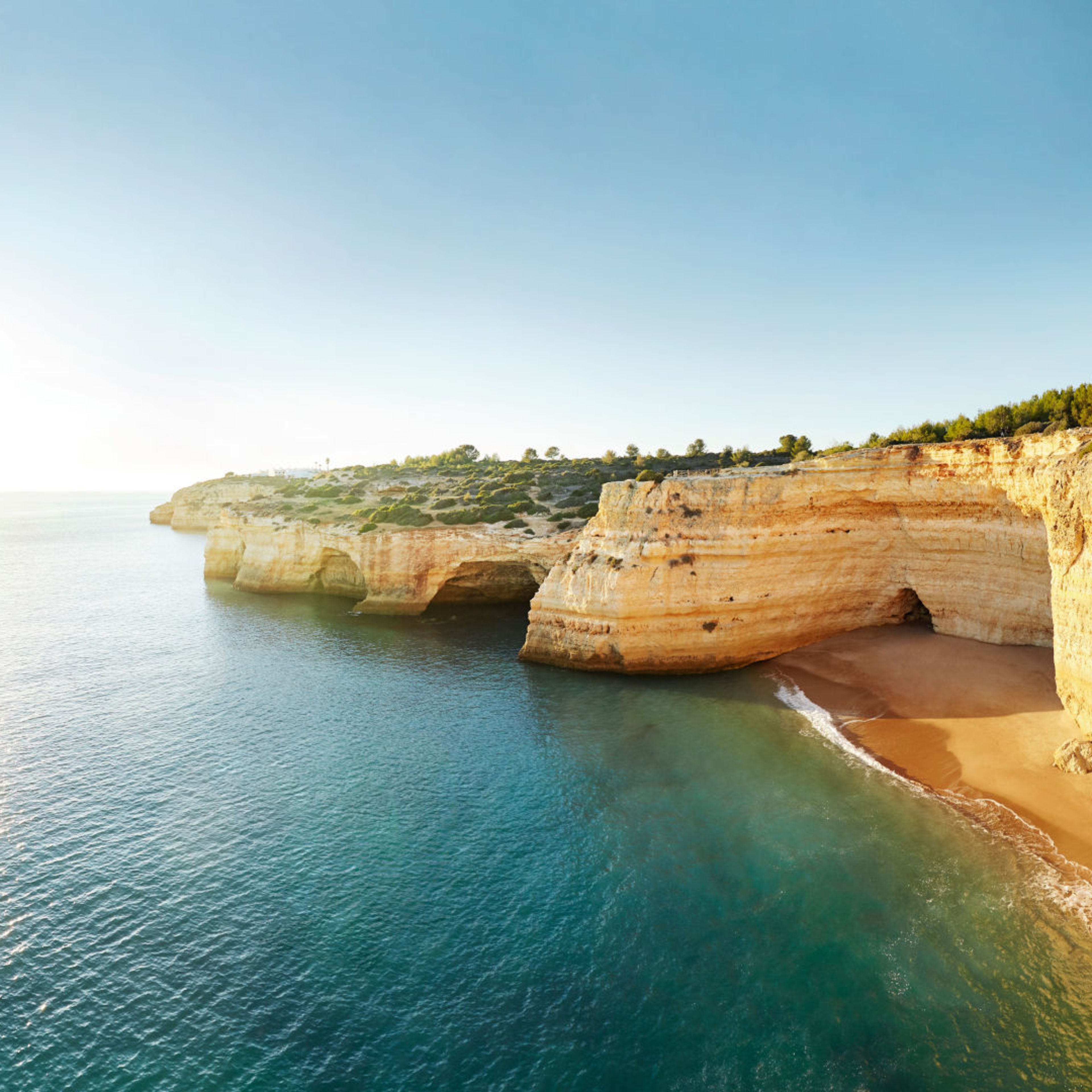 Küste der Algarve mit goldenen Klippen und blauem Meer. Küste der Algarve mit goldenen Klippen und blauem Meer.