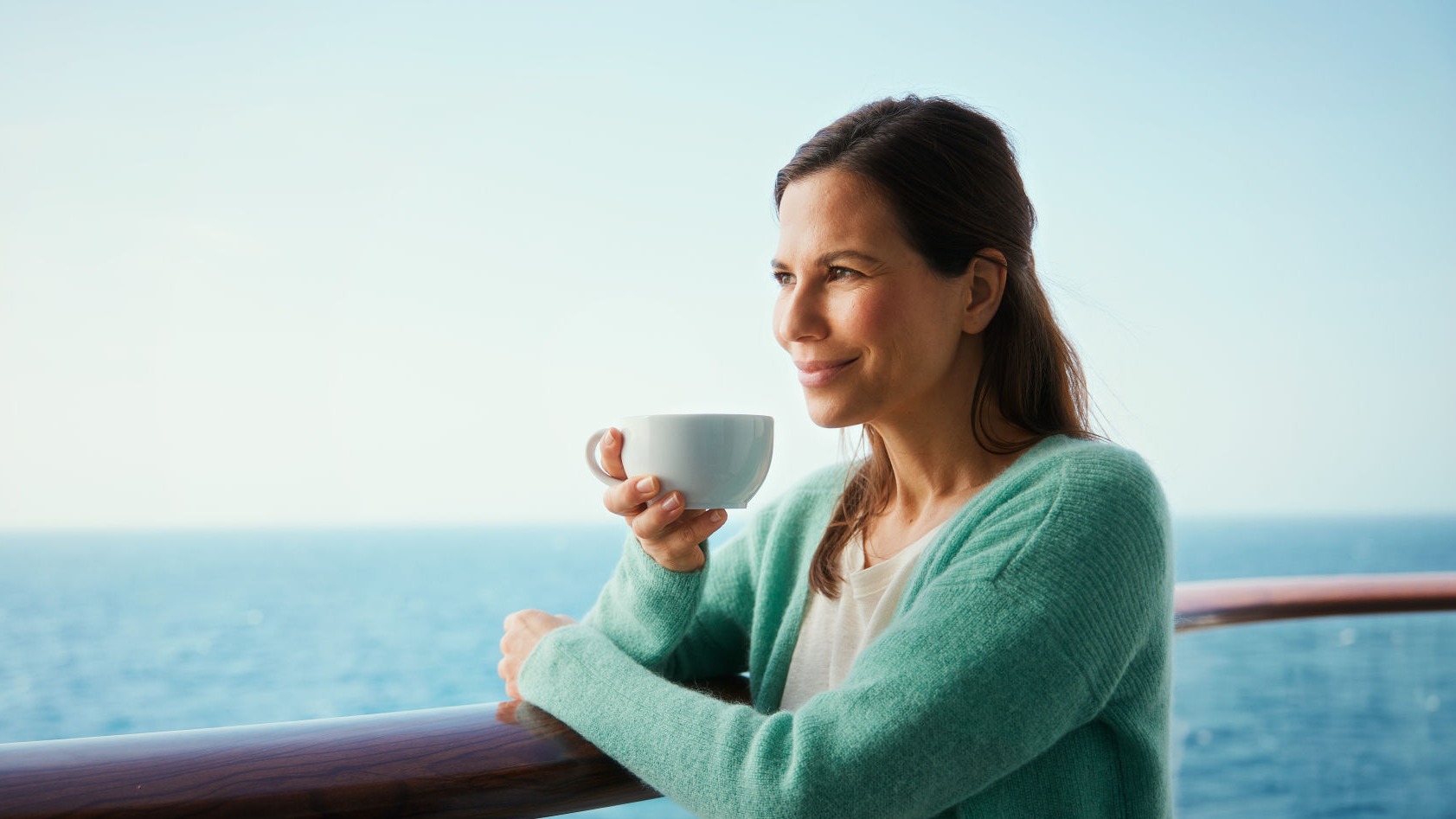 Frau genießt Kaffee auf Kreuzfahrtschiff, Meerblick.