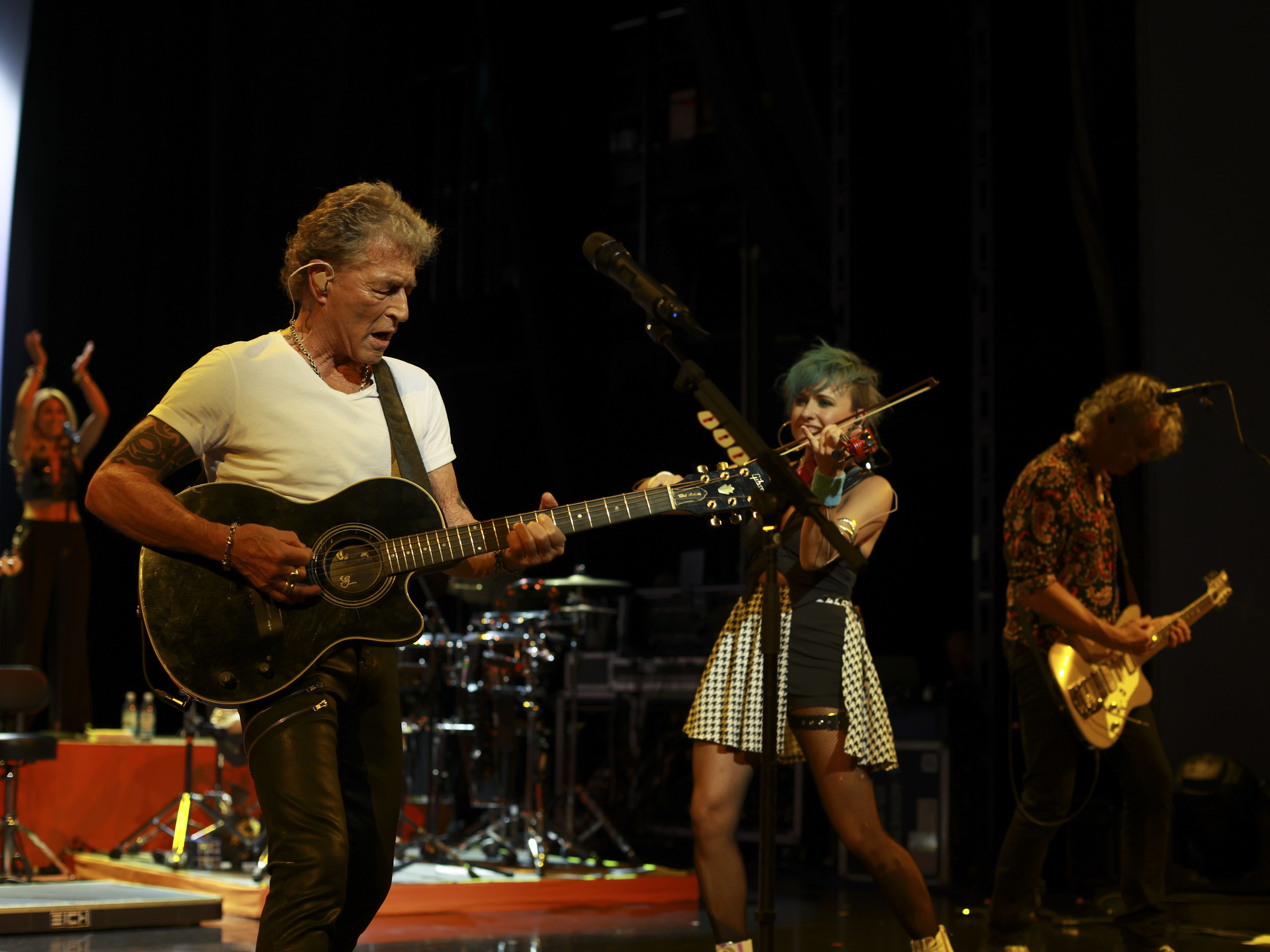 Musiker auf Bühne mit Gitarre und Geige, lebhafte Performance. Musiker auf Bühne mit Gitarre und Geige, lebhafte Performance.