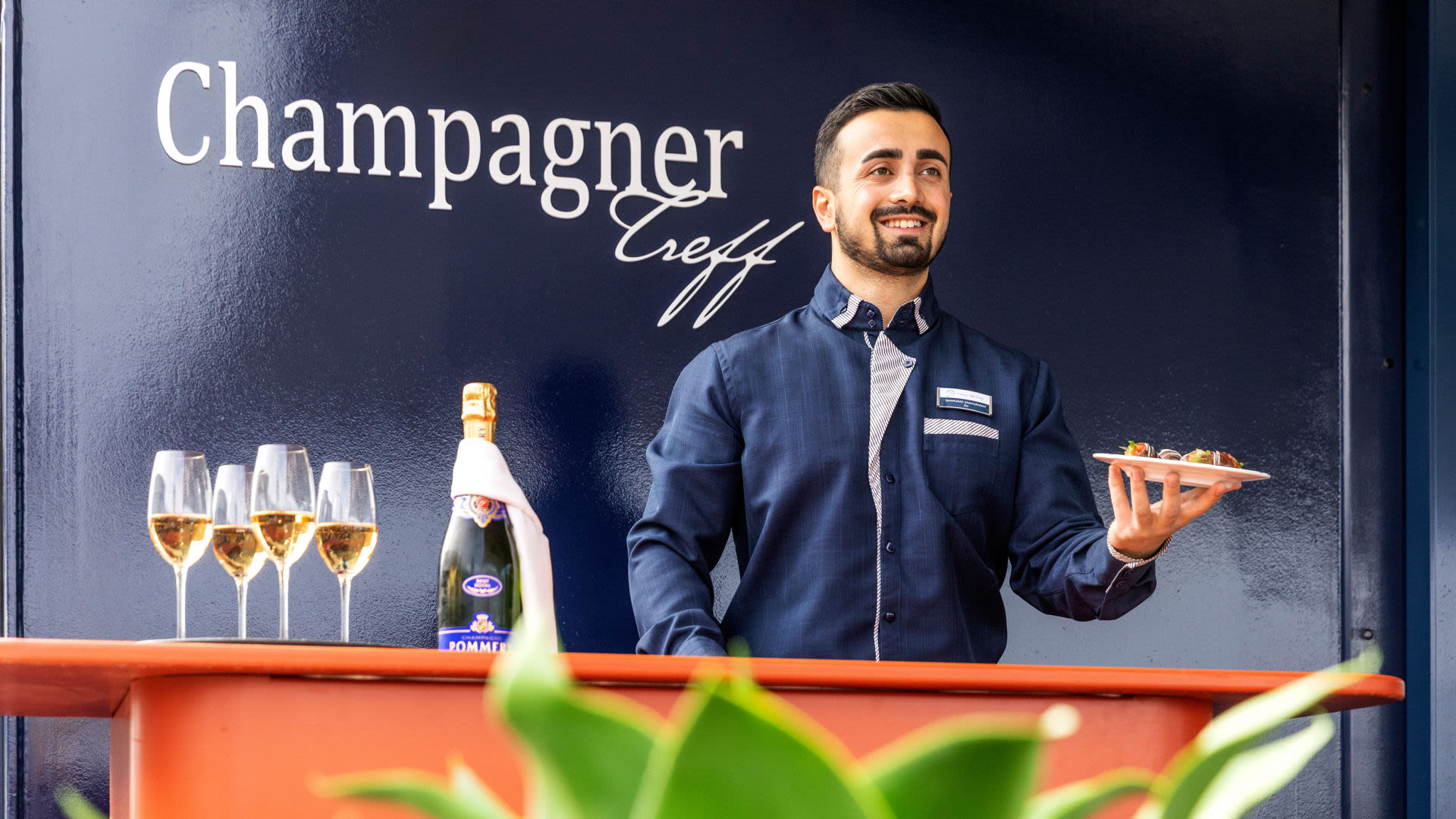 Kellner serviert Champagner und Häppchen im Champagner Treff.
