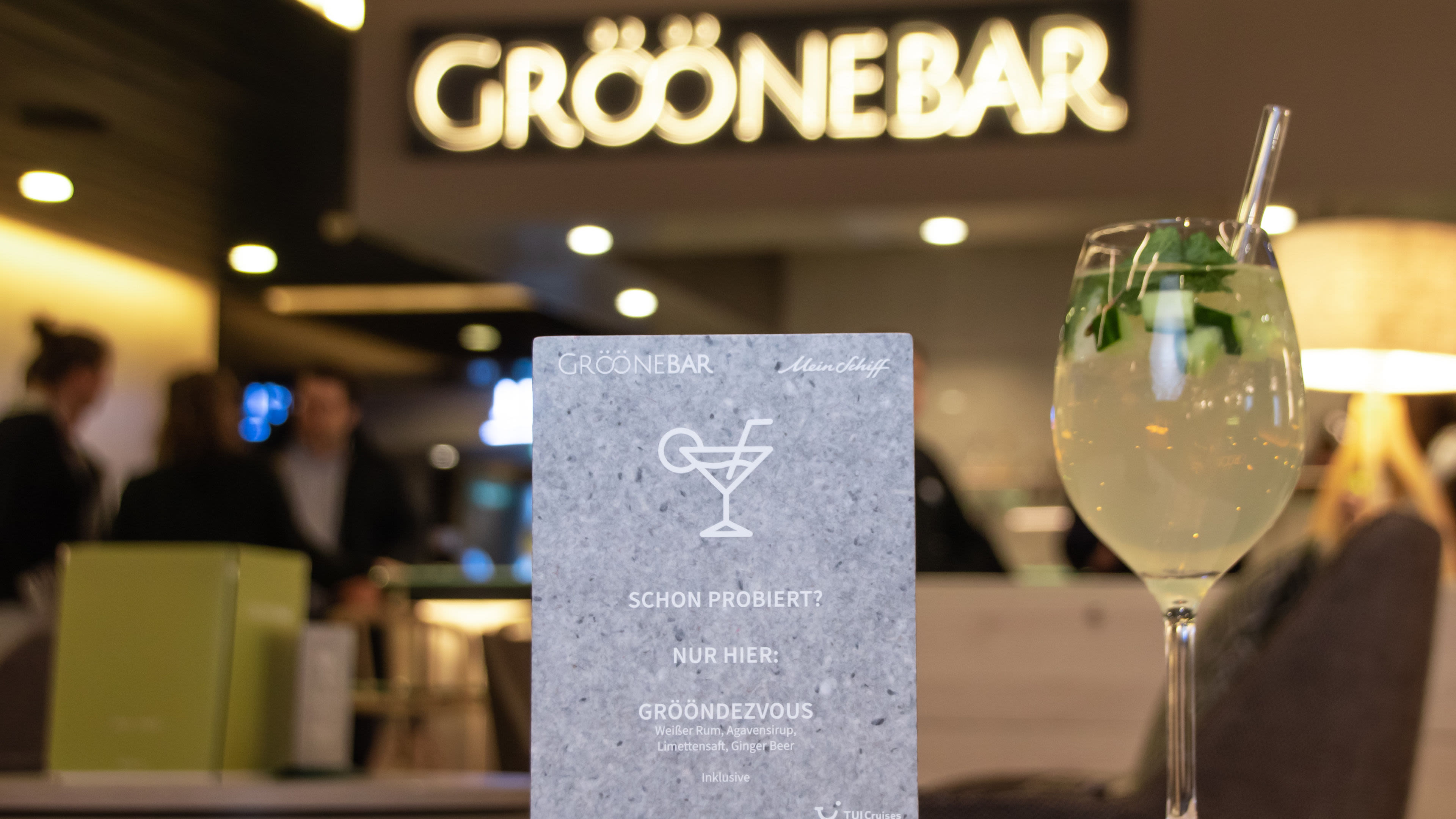 Grööne Bar Schild und Cocktailglas, unscharfer Hintergrund.