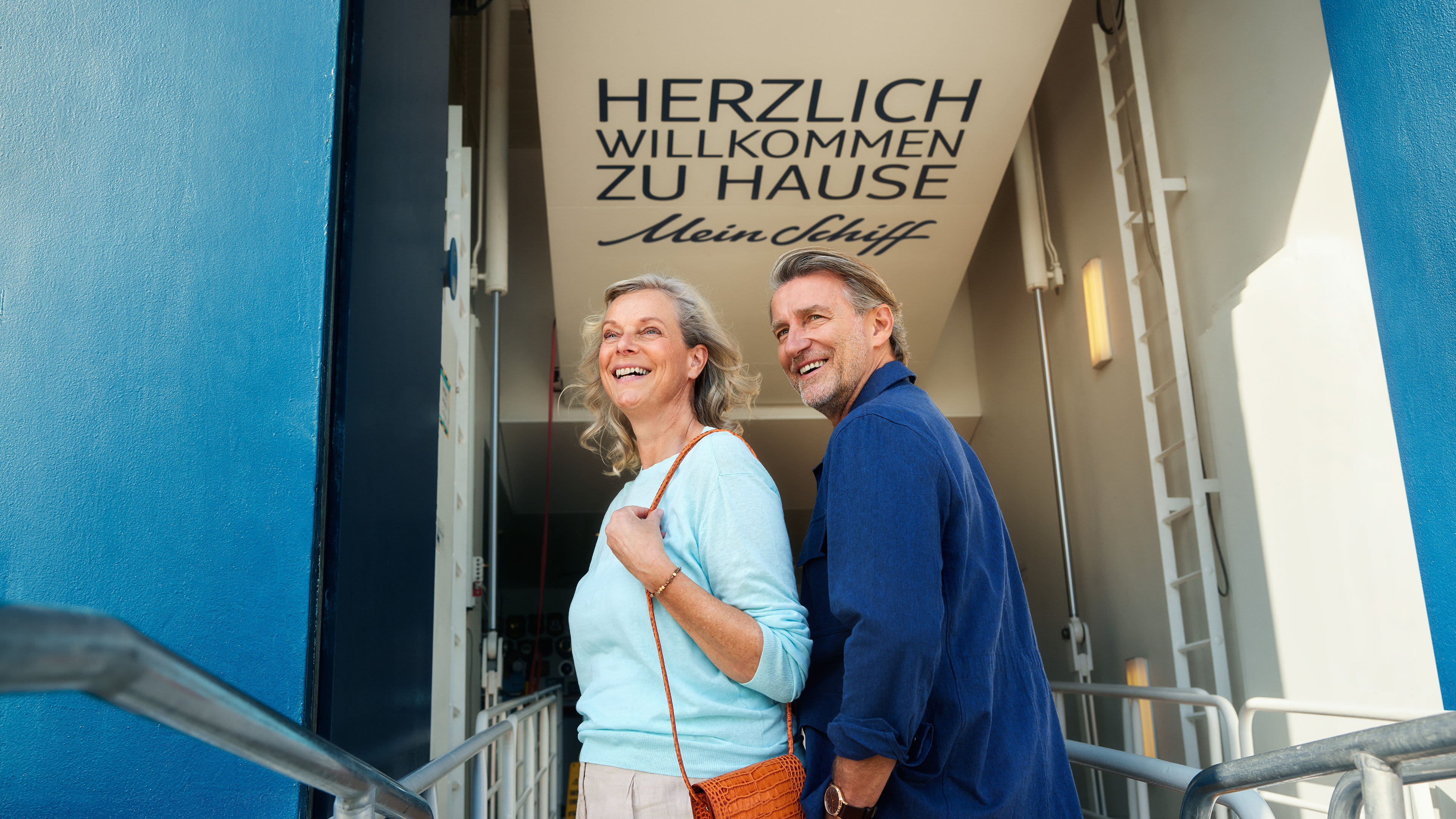 Lächelndes Paar betritt Kreuzfahrtschiff der Mein Schiff® Flotte.