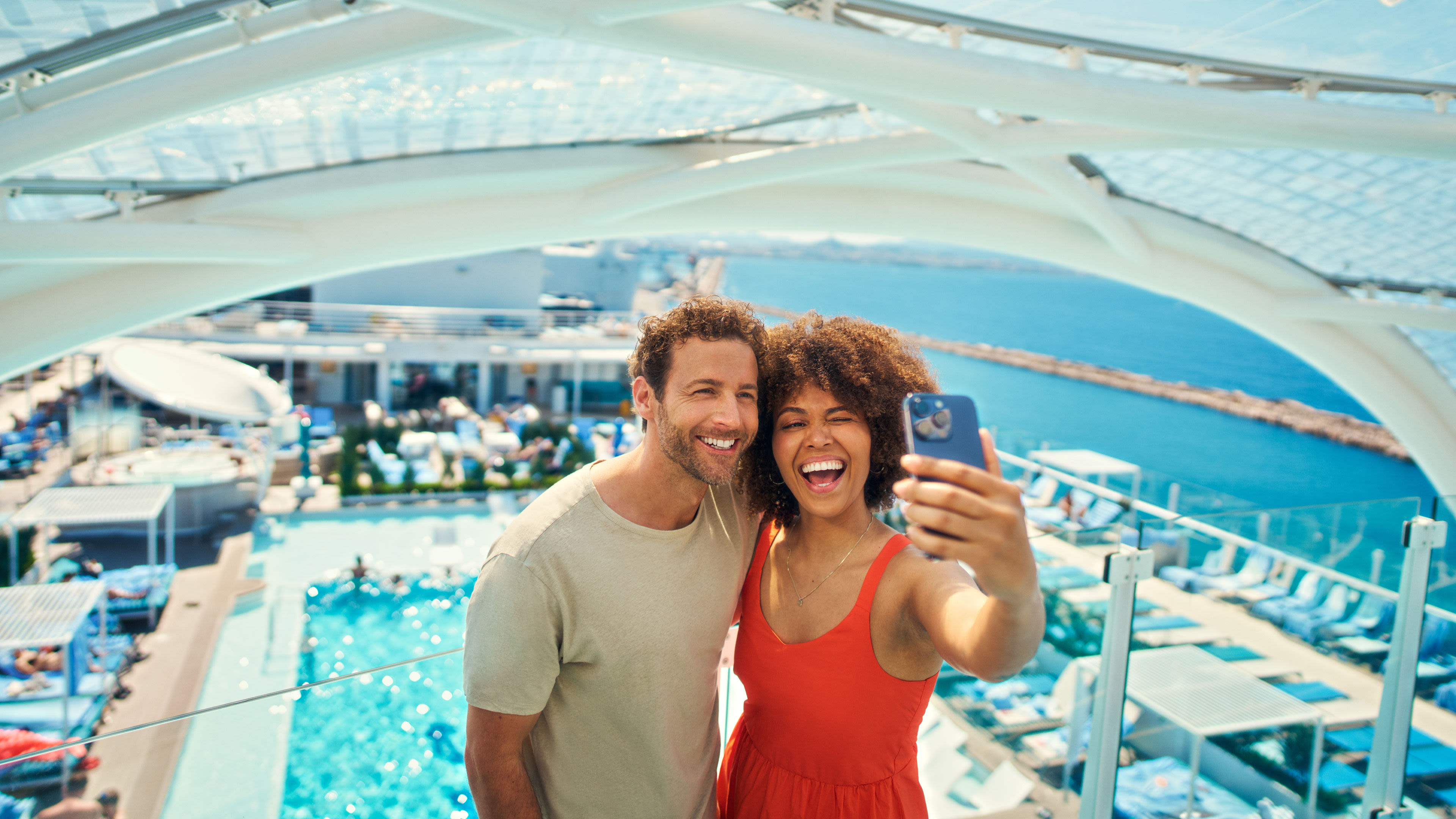 Paar macht Selfie auf Kreuzfahrtschiff der Mein Schiff® Flotte, Pool im Hintergrund. Paar macht Selfie auf Kreuzfahrtschiff der Mein Schiff® Flotte, Pool im Hintergrund.