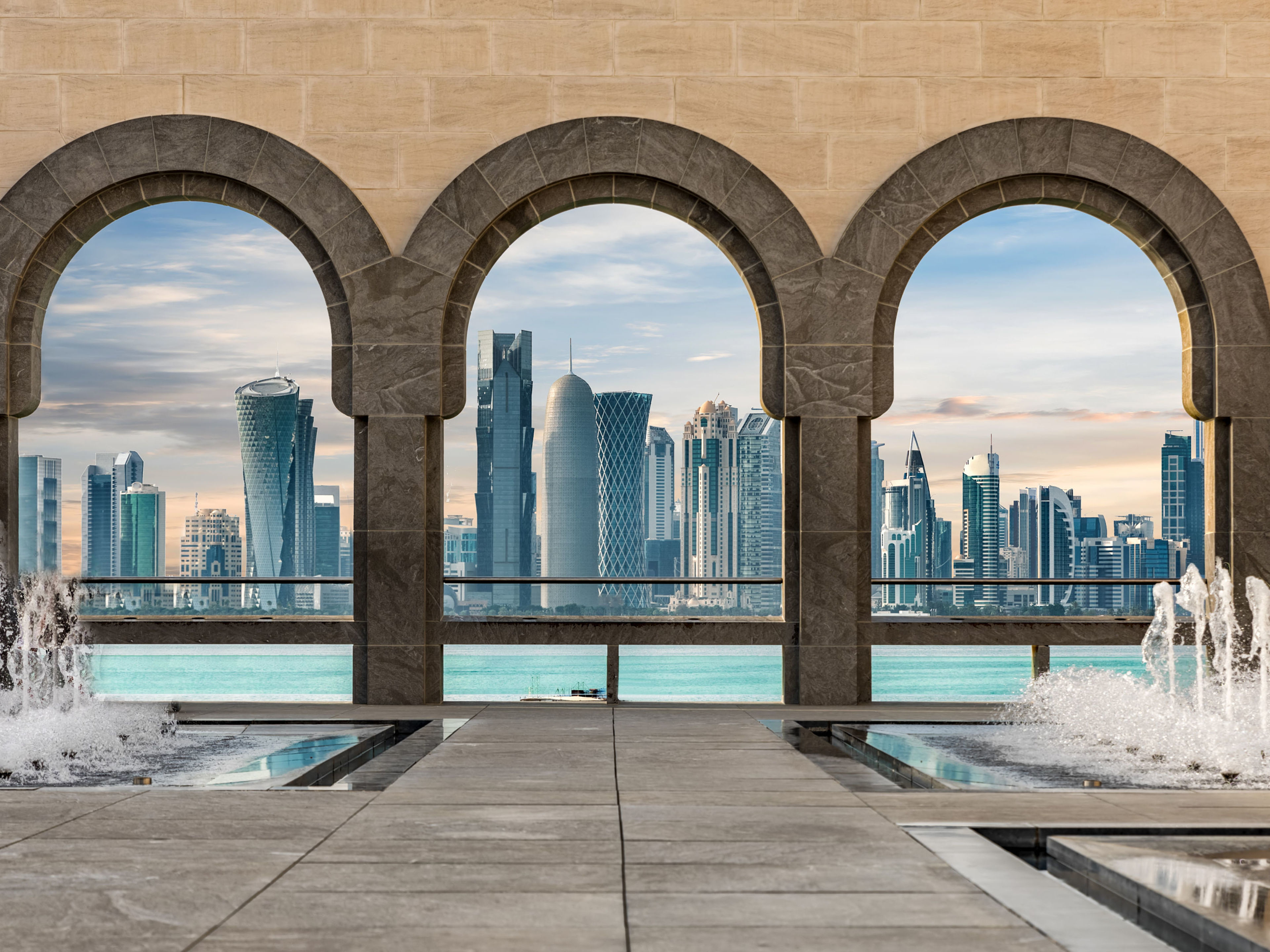 Drei Bögen mit Blick auf Dohas Skyline und Springbrunnen. Drei Bögen mit Blick auf Dohas Skyline und Springbrunnen.