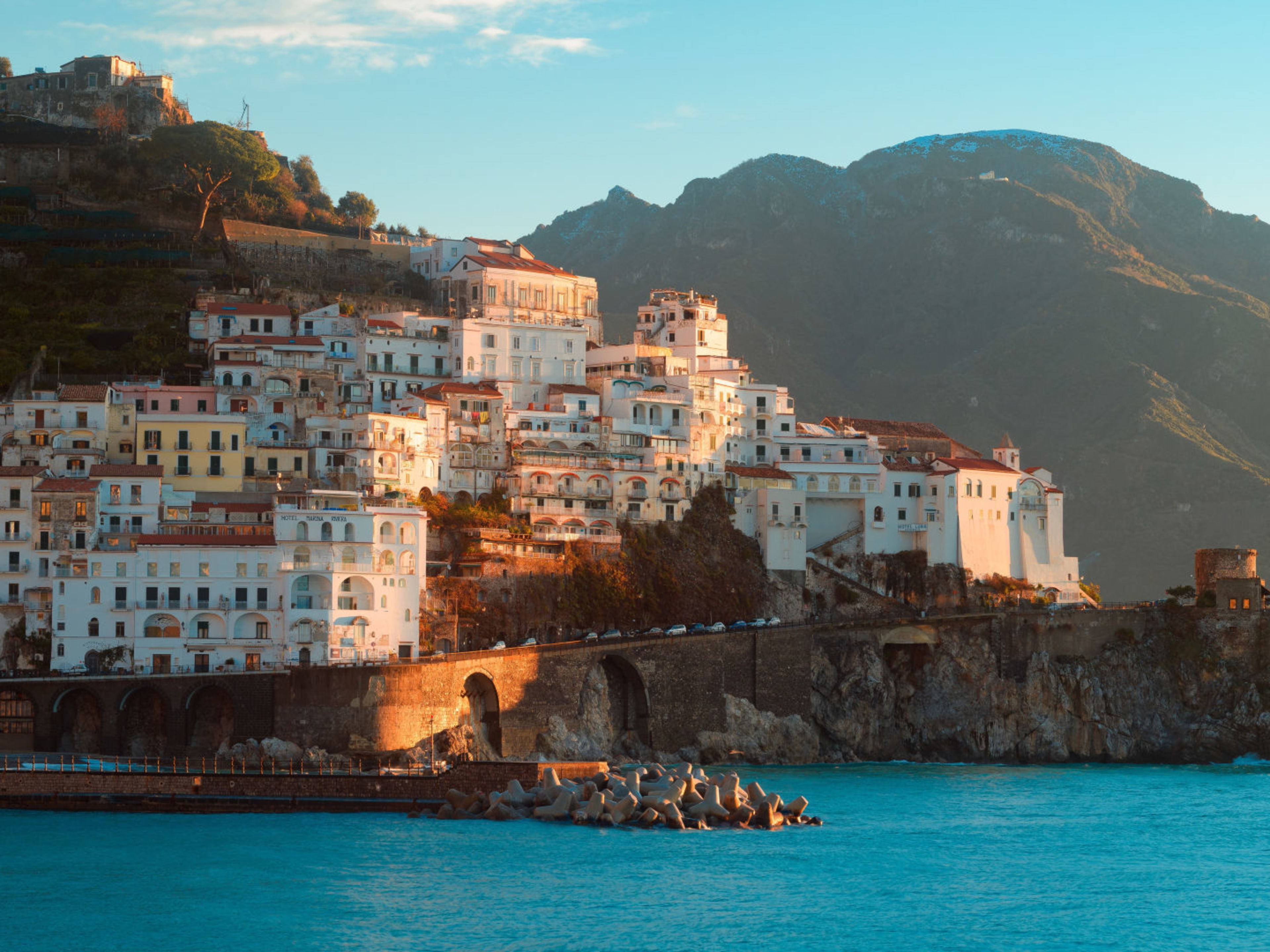 Küstenstadt Amalfi bei Sonnenuntergang, bunte Häuser, blaues Meer. Küstenstadt Amalfi bei Sonnenuntergang, bunte Häuser, blaues Meer.