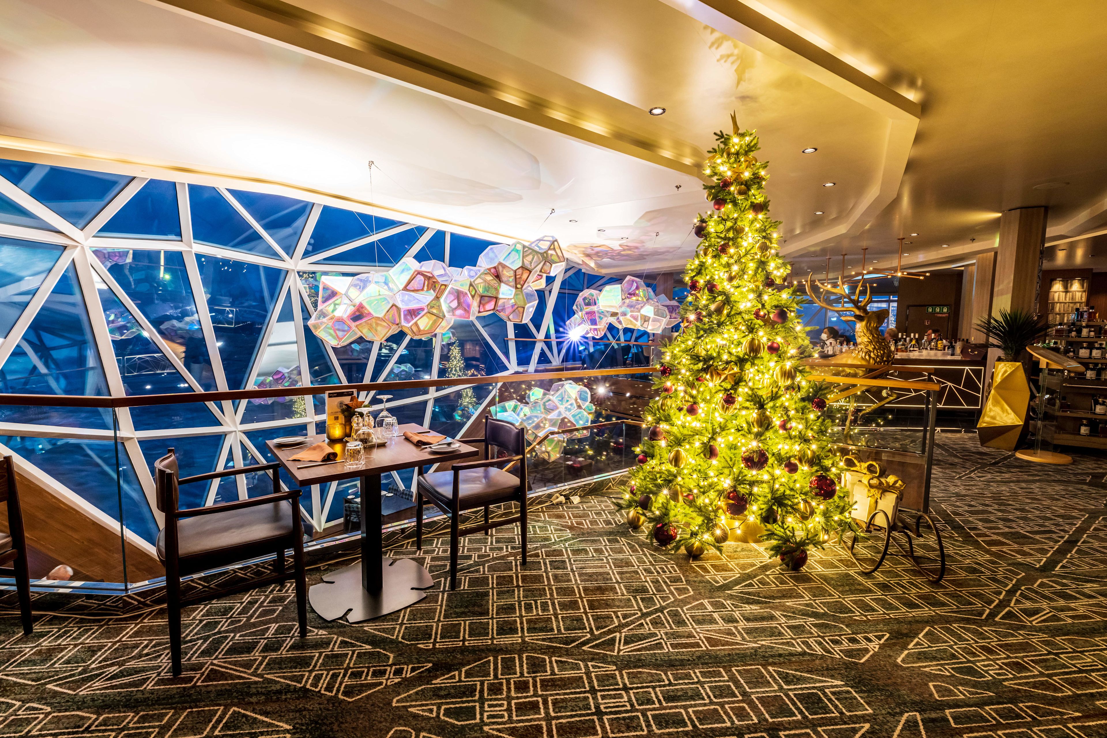 Weihnachtsbaum im Restaurant, festlich dekoriert, mit Lichtern und Geschenken. Weihnachtsbaum im Restaurant, festlich dekoriert, mit Lichtern und Geschenken.