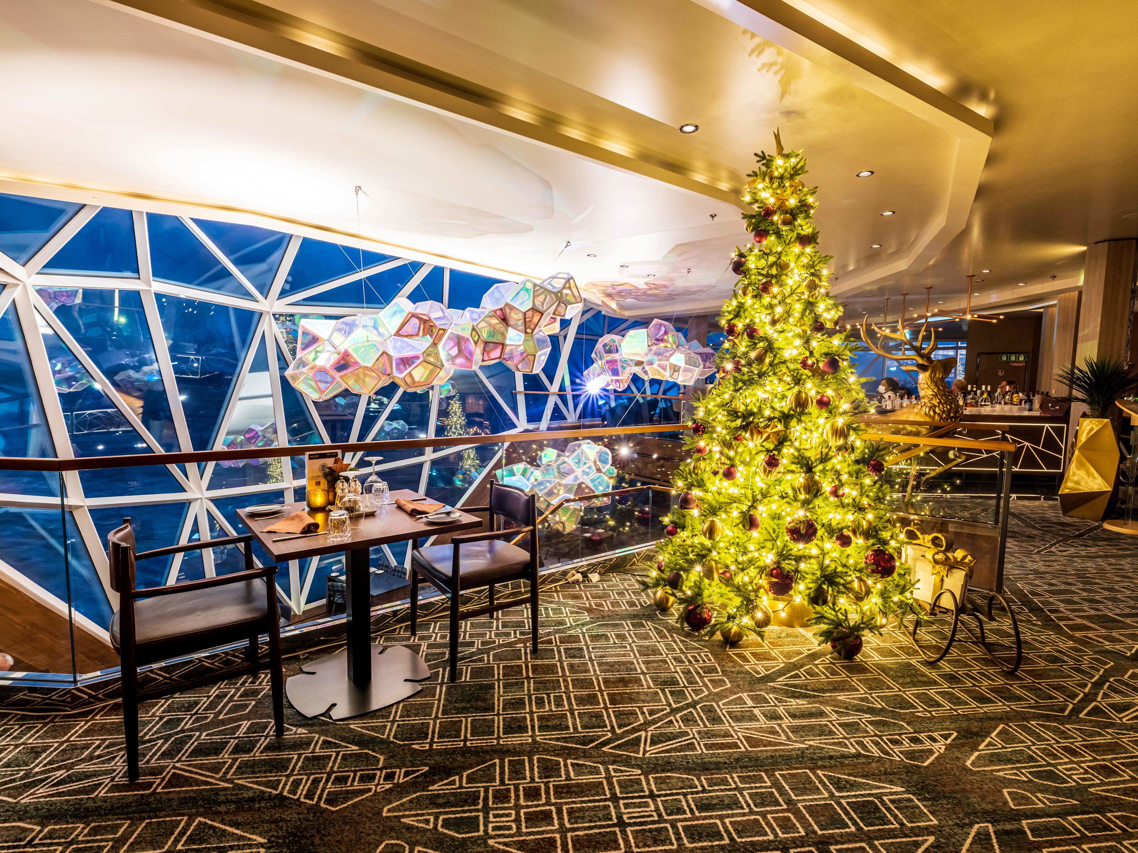 Weihnachtsbaum im Restaurant, festlich dekoriert, mit Lichtern und Geschenken. Weihnachtsbaum im Restaurant, festlich dekoriert, mit Lichtern und Geschenken.