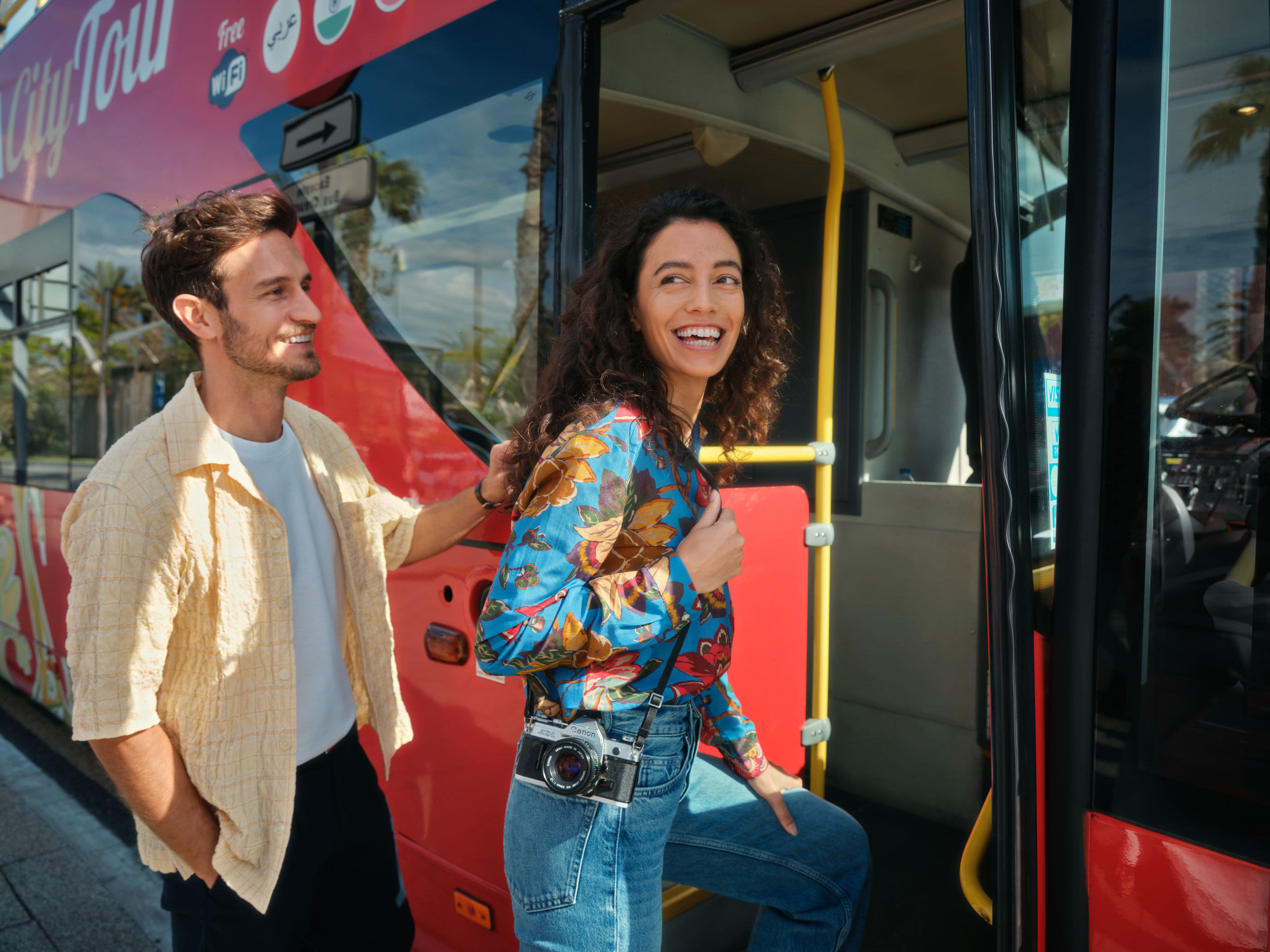 Paar steigt in roten Sightseeing-Bus ein, lächelnd. Paar steigt in roten Sightseeing-Bus ein, lächelnd.
