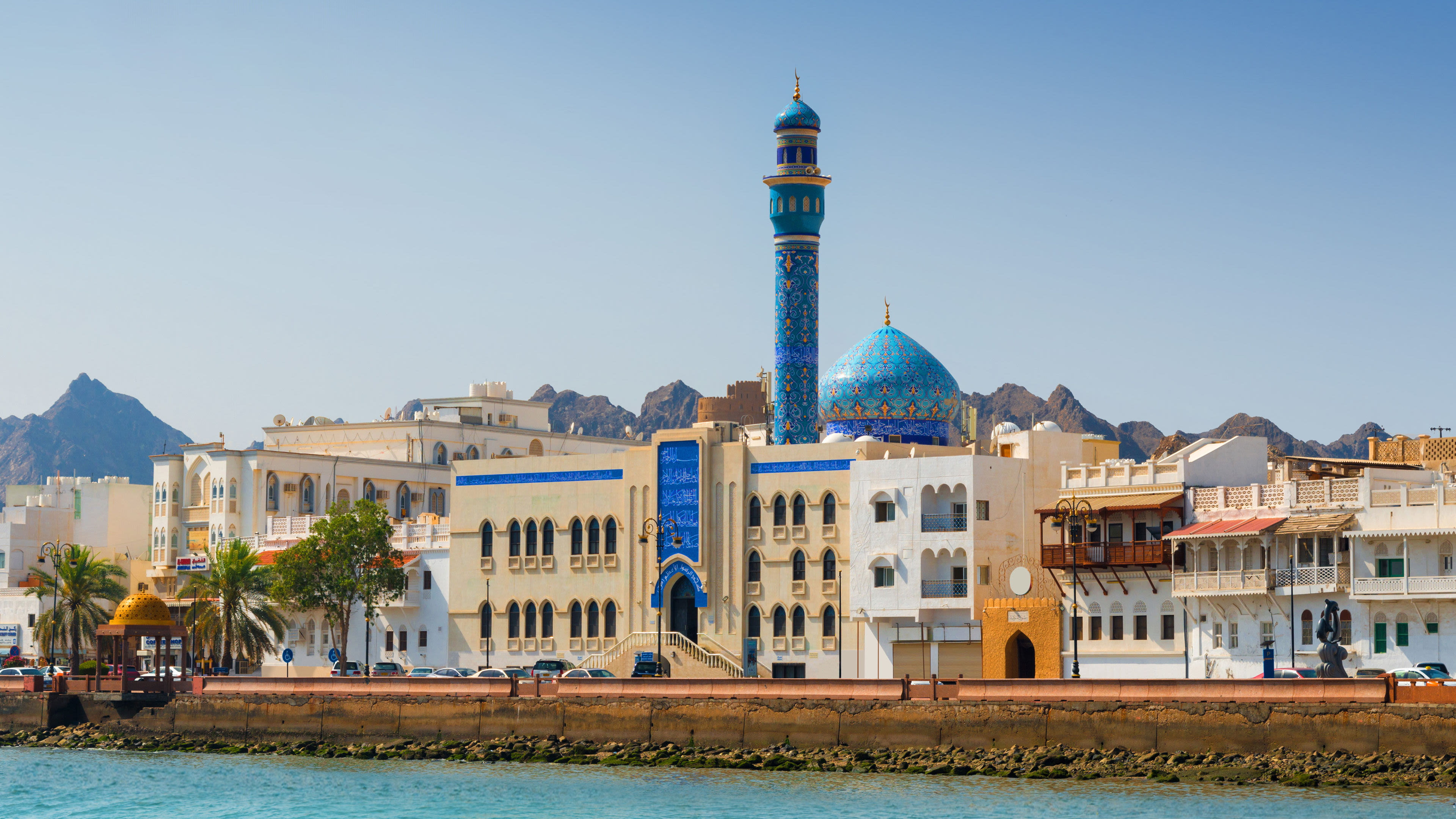 Blaue Moschee und Gebäude in Maskat, Oman, vor Bergen.