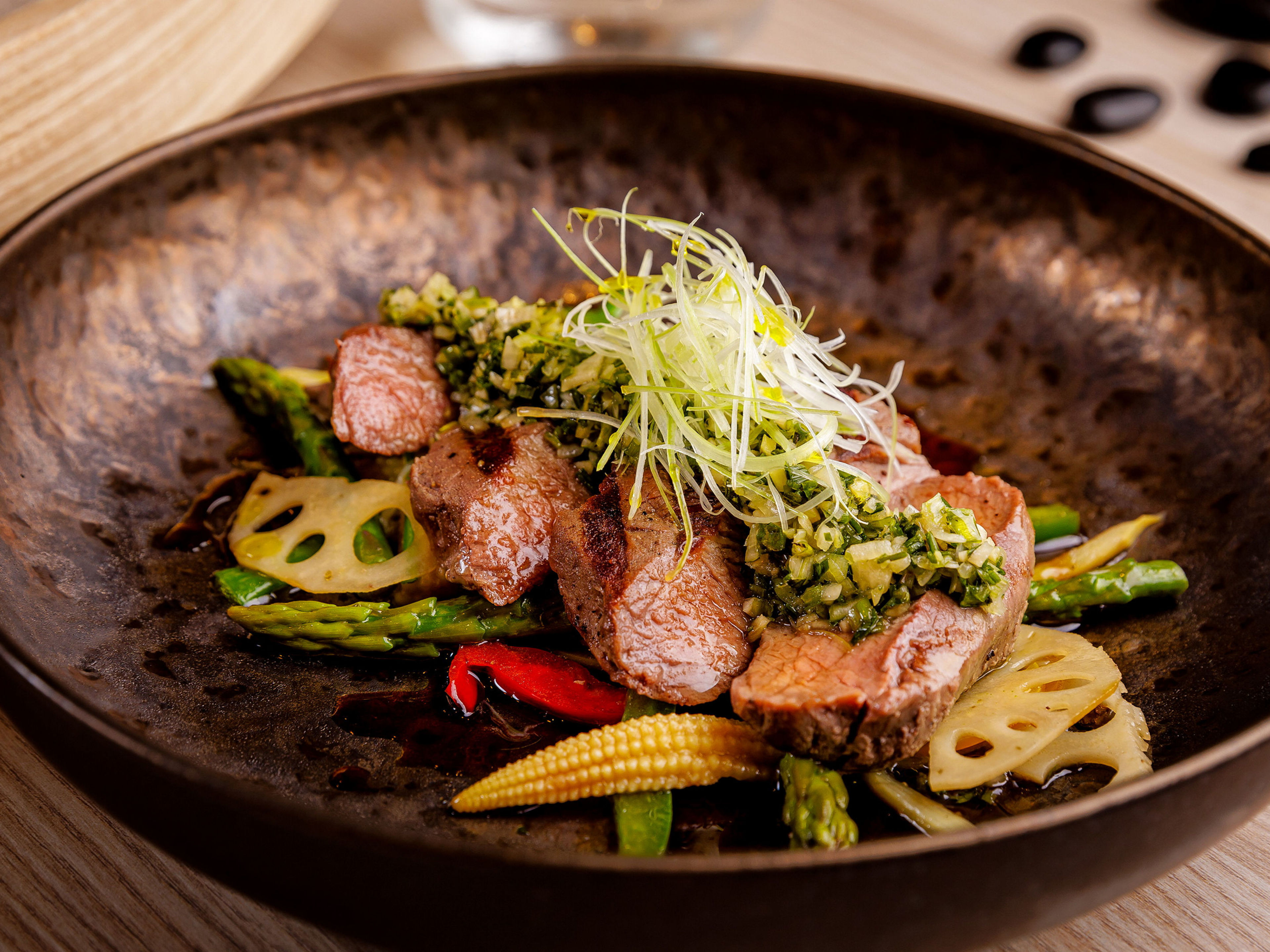 Gourmetgericht mit Fleisch, Gemüse und Kräutern in brauner Schale. Gourmetgericht mit Fleisch, Gemüse und Kräutern in brauner Schale.
