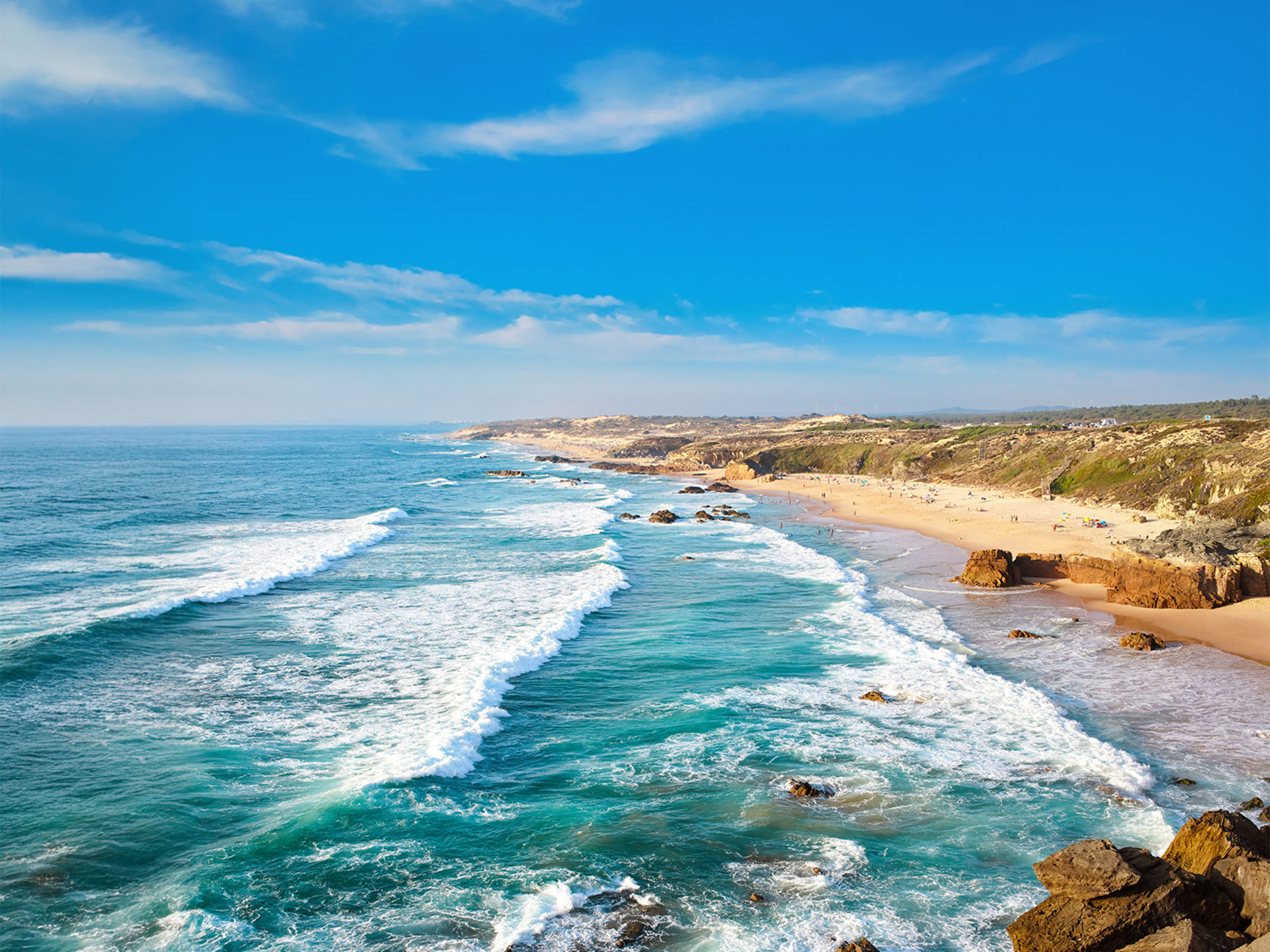Küste mit Wellen, blauem Himmel und Sandstrand in Portugal. Küste mit Wellen, blauem Himmel und Sandstrand in Portugal.