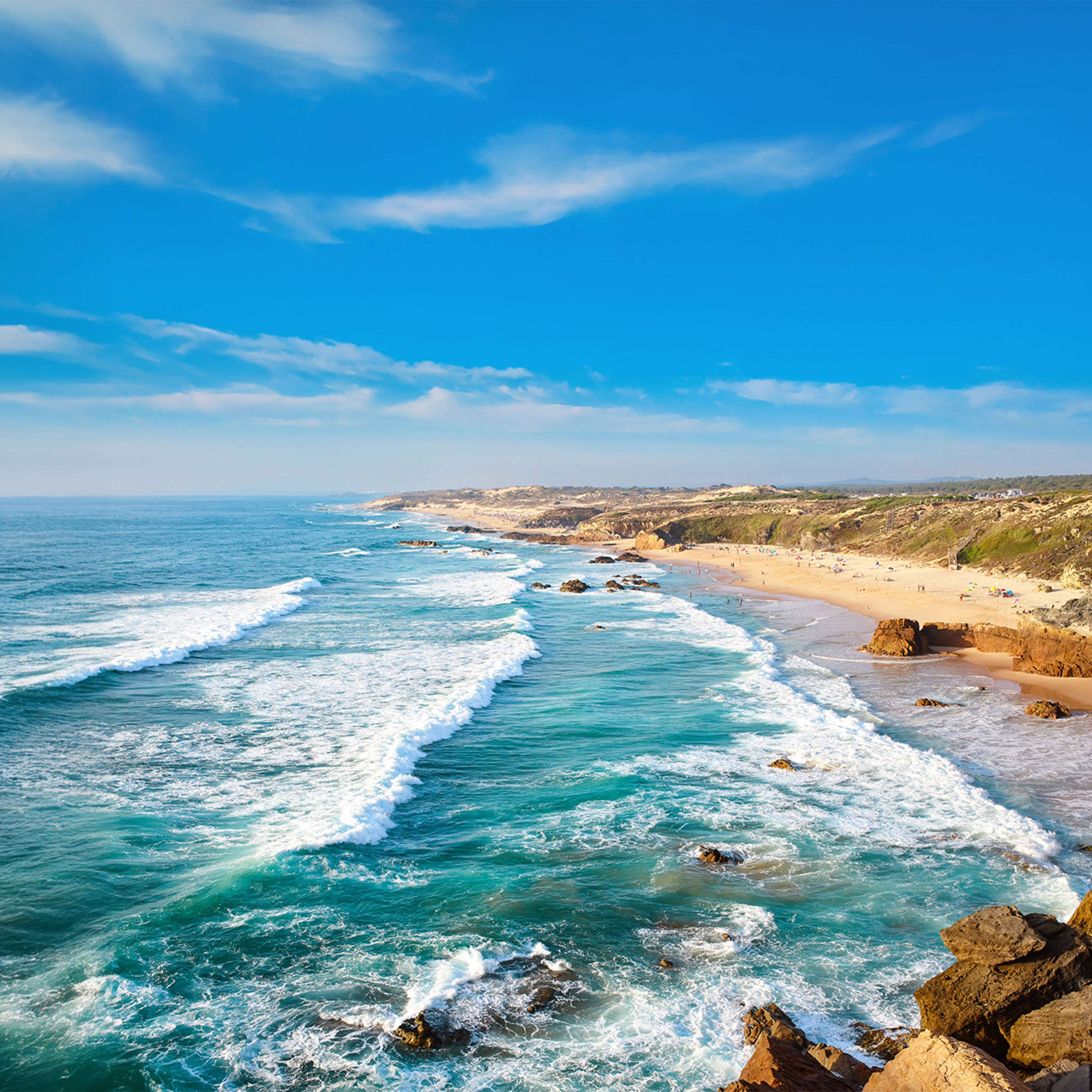 Küste mit Wellen, blauem Himmel und Sandstrand in Portugal. Küste mit Wellen, blauem Himmel und Sandstrand in Portugal.