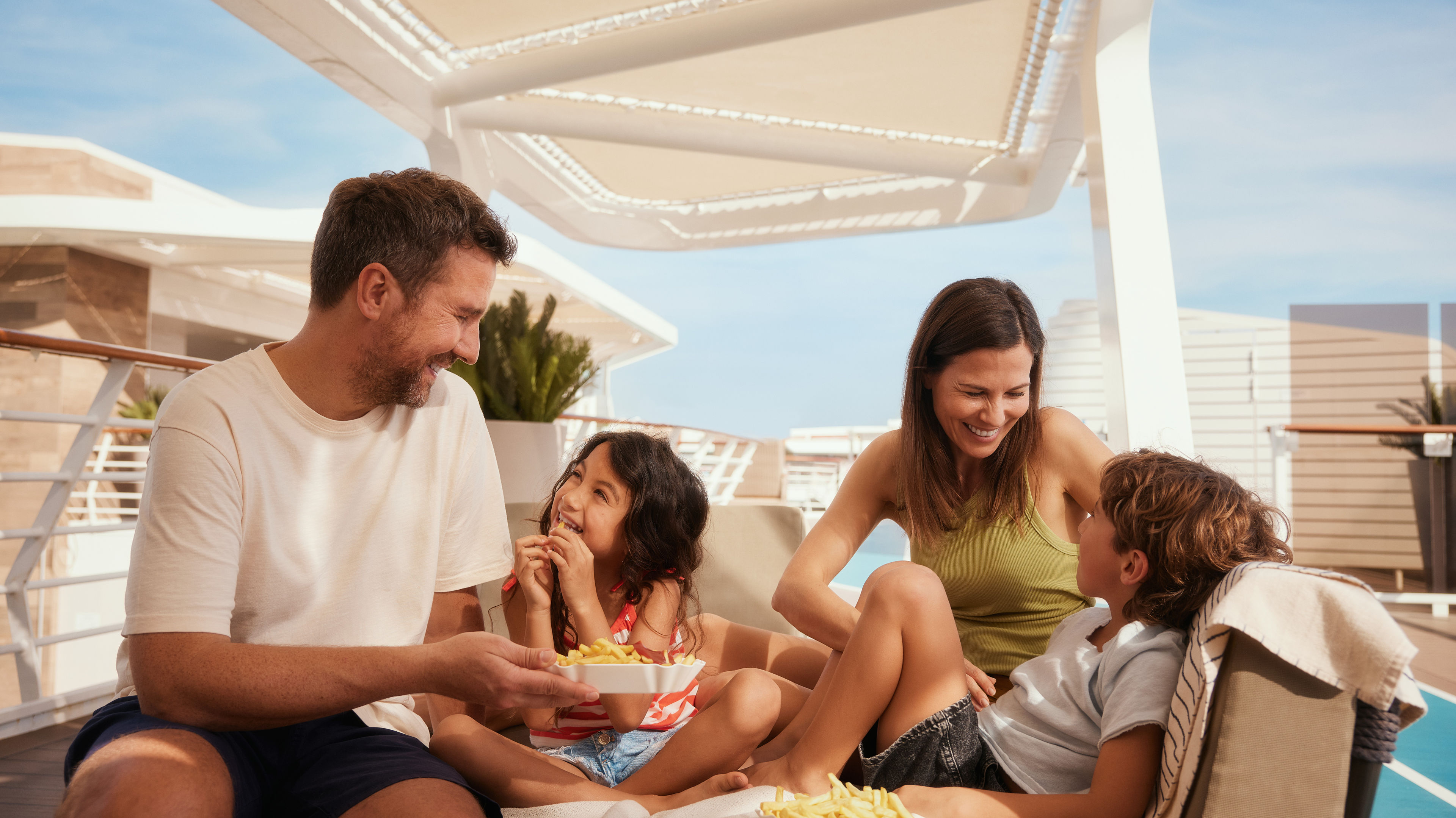 Familie genießt Pommes auf Kreuzfahrtschiff der Mein Schiff® Flotte.