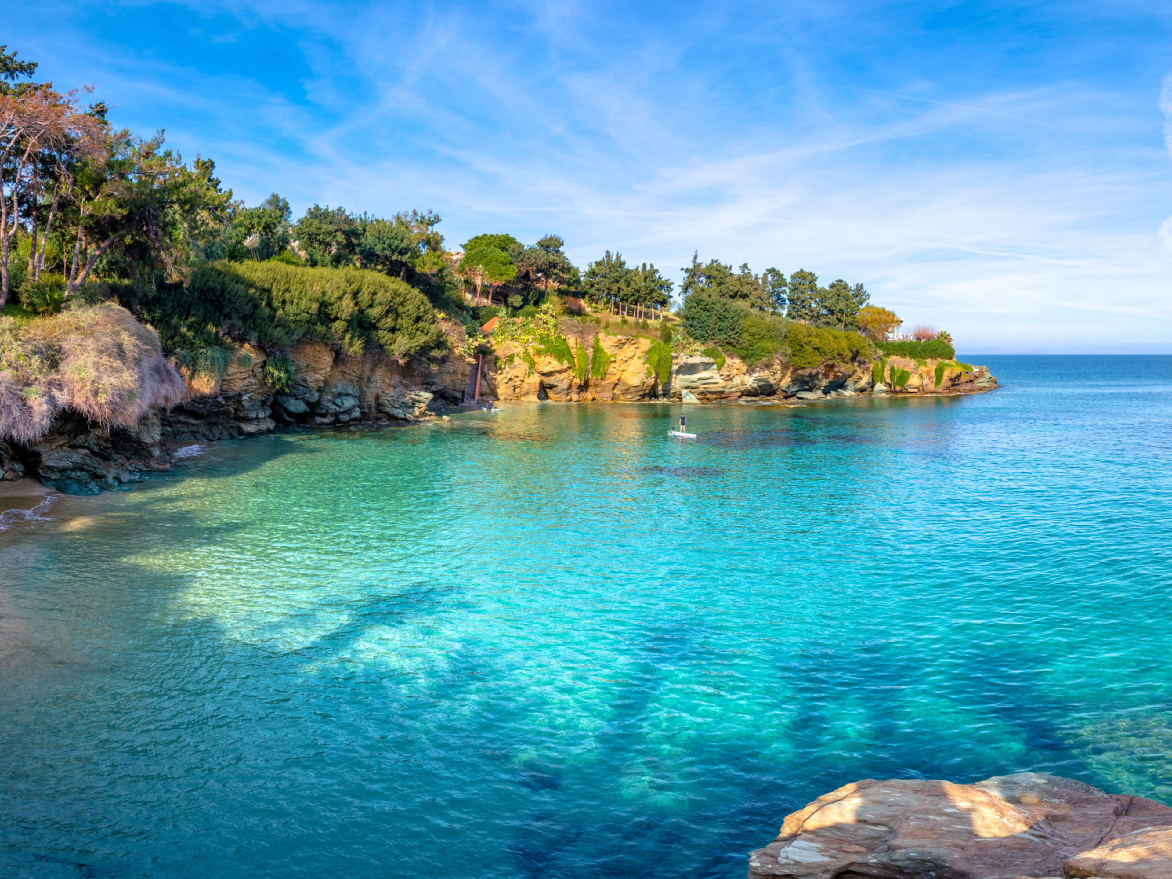 Kleine Bucht mit türkisfarbenem Wasser und grünen Klippen. Kleine Bucht mit türkisfarbenem Wasser und grünen Klippen.