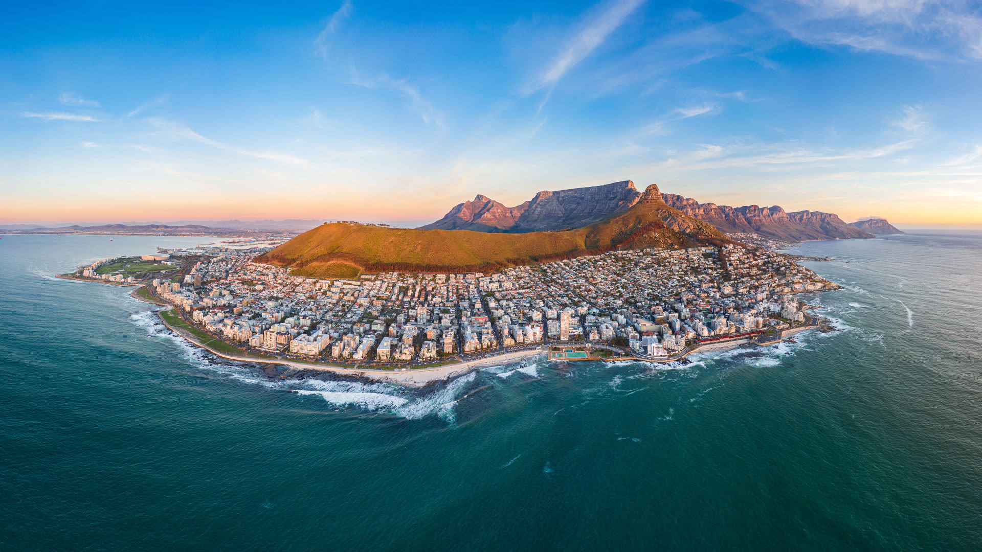 Luftaufnahme von Kapstadt mit Tafelberg und Küste bei Sonnenuntergang.
