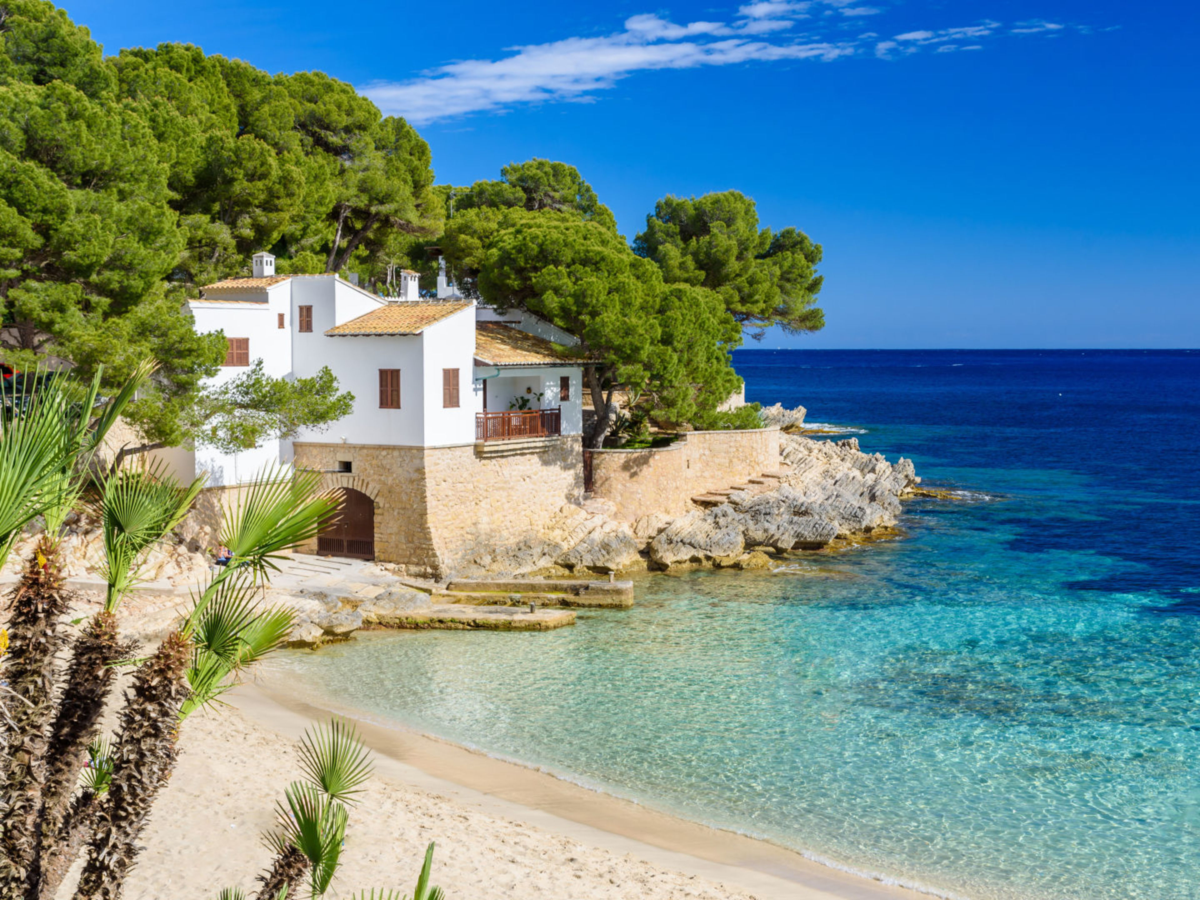 Weißes Haus am Strand von Mallorca, umgeben von Pinien. Weißes Haus am Strand von Mallorca, umgeben von Pinien.
