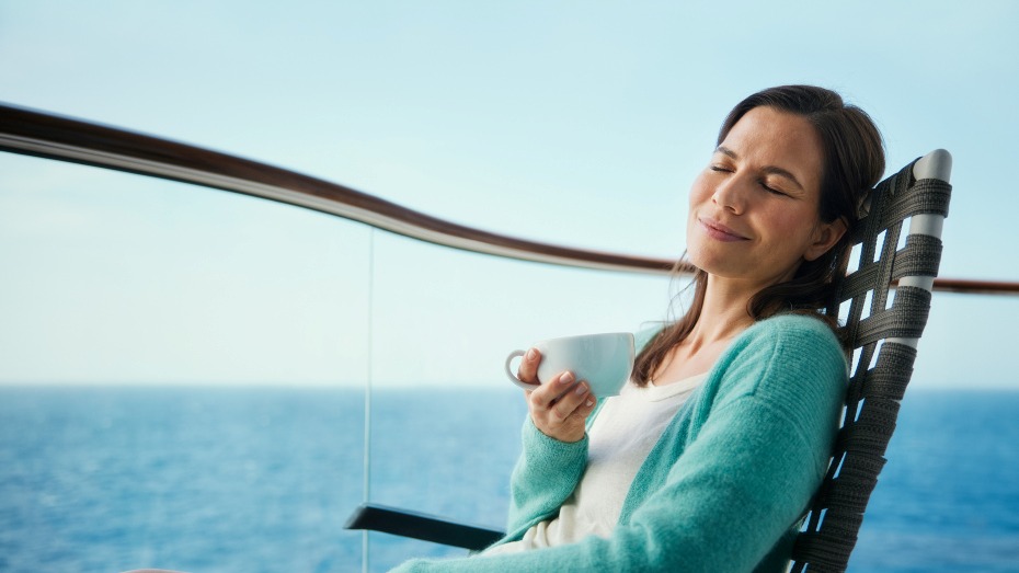 Frau entspannt mit Tasse auf Kreuzfahrtschiff, Meerblick.